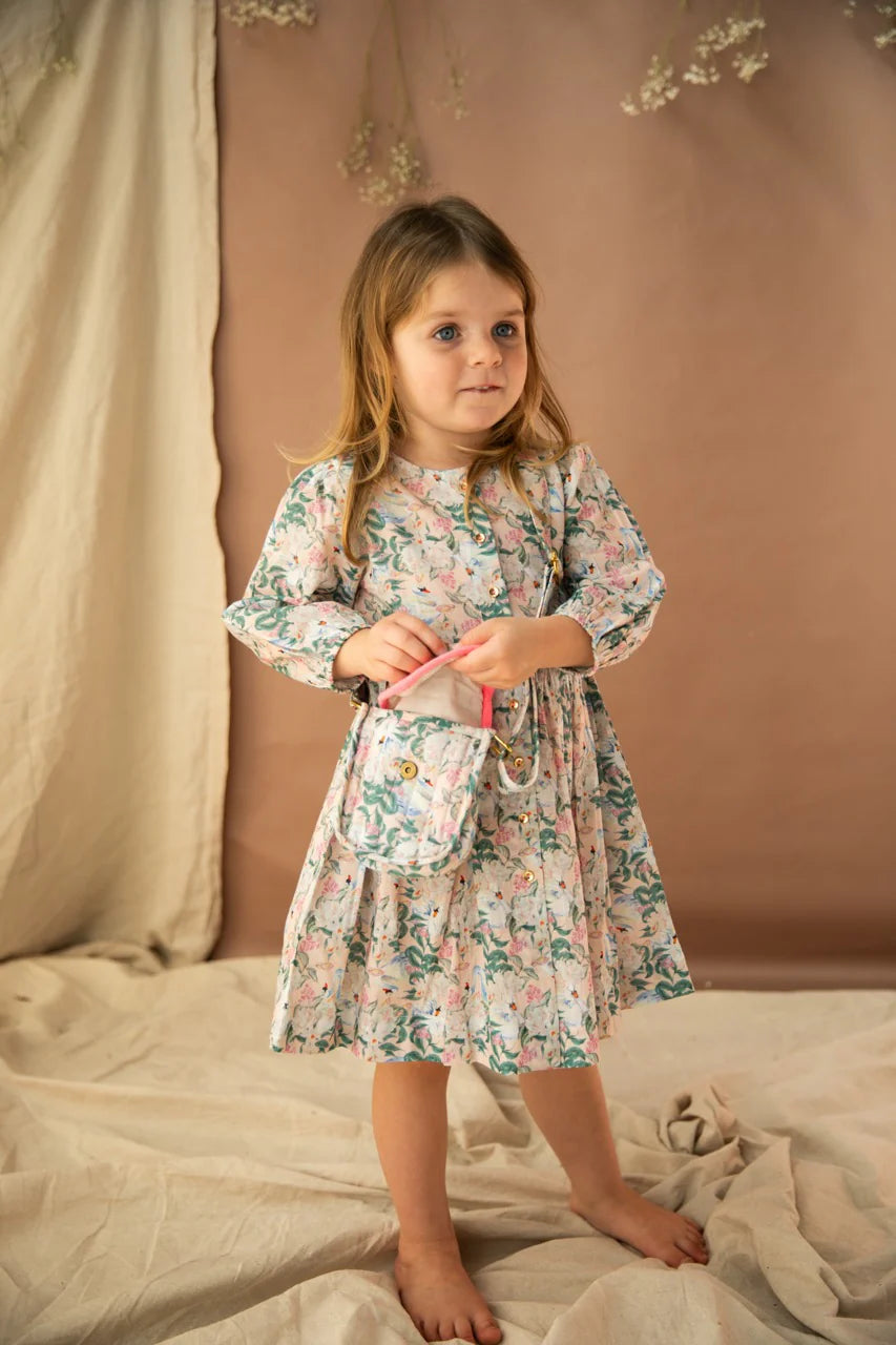 A young girl wearing the treasures bag with the hello gorgeous print. She is also wearing a dress in the same print.