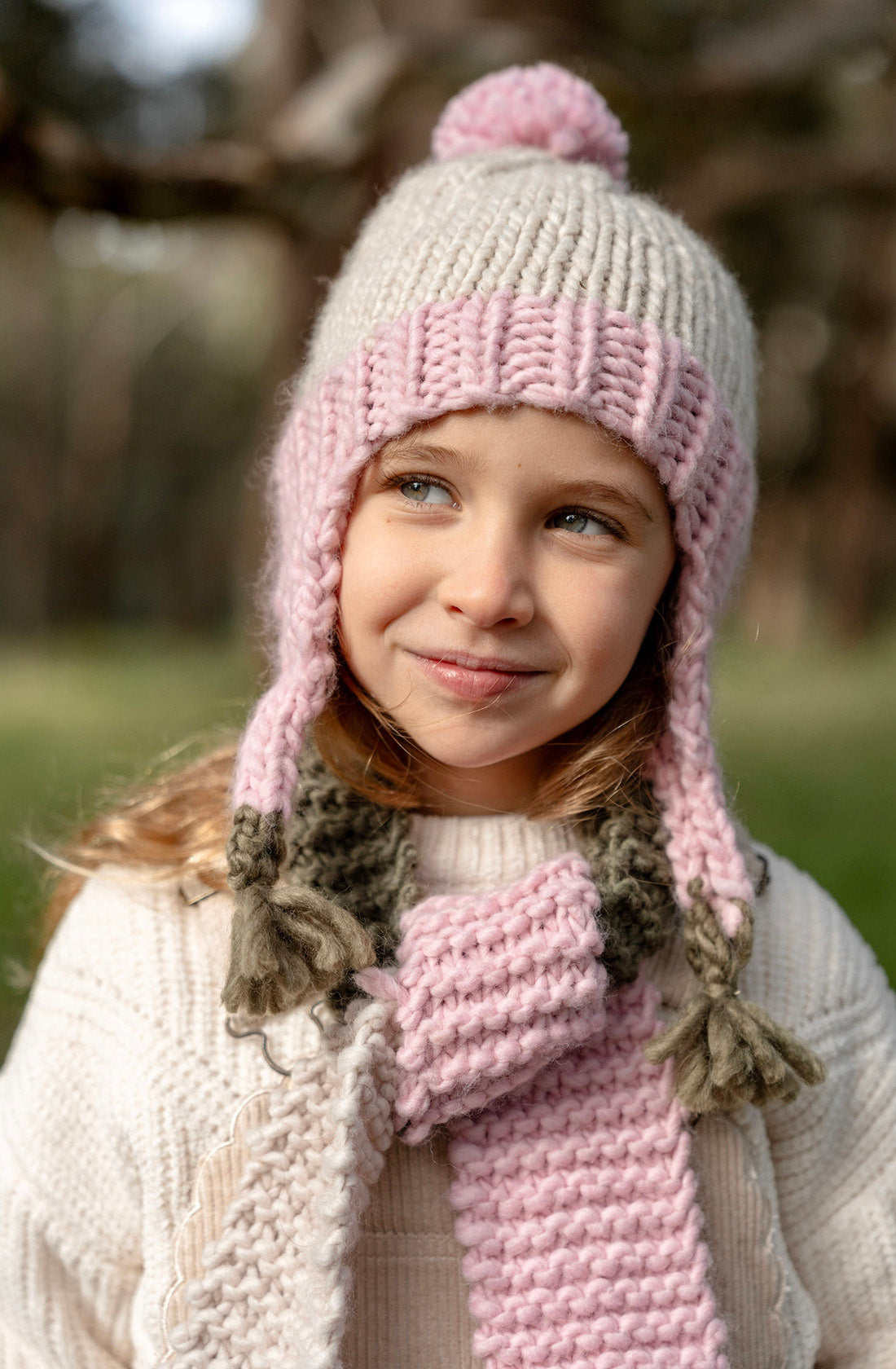 A young girl wearing the Acorn earth blossom beanie.