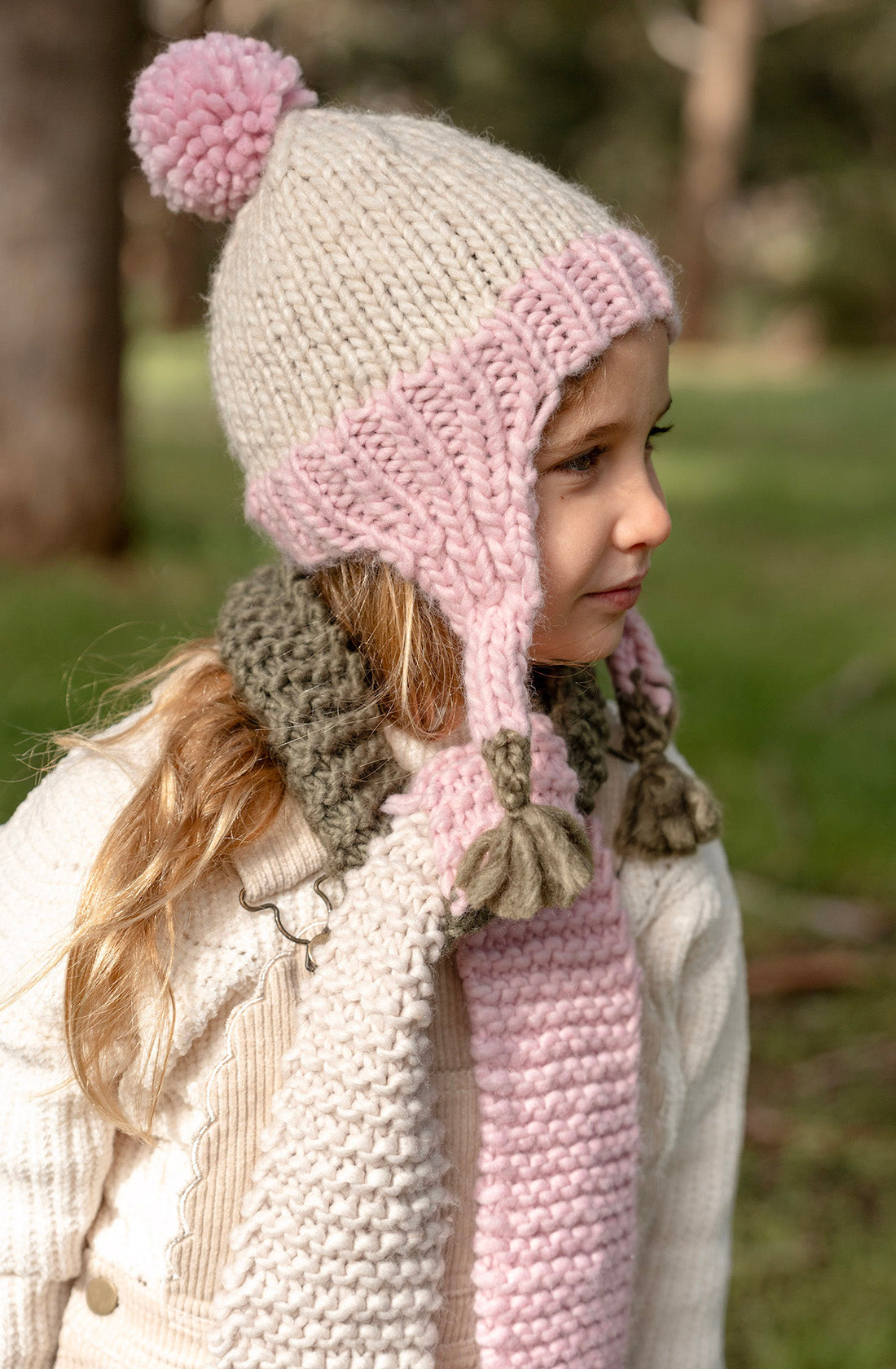 A young girl wearing the Acorn earth blossom beanie facing away from the camera showing a side view of her face.