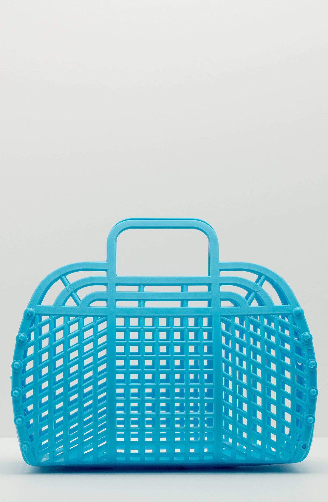 A turquoise plastic basket with a lattice design sits on a neutral background. The BPA-free, Medium Retro Jelly Basket from BAY KIDS has two handles at the top and a rectangular shape with rounded edges. The overall aesthetic is simple and functional.