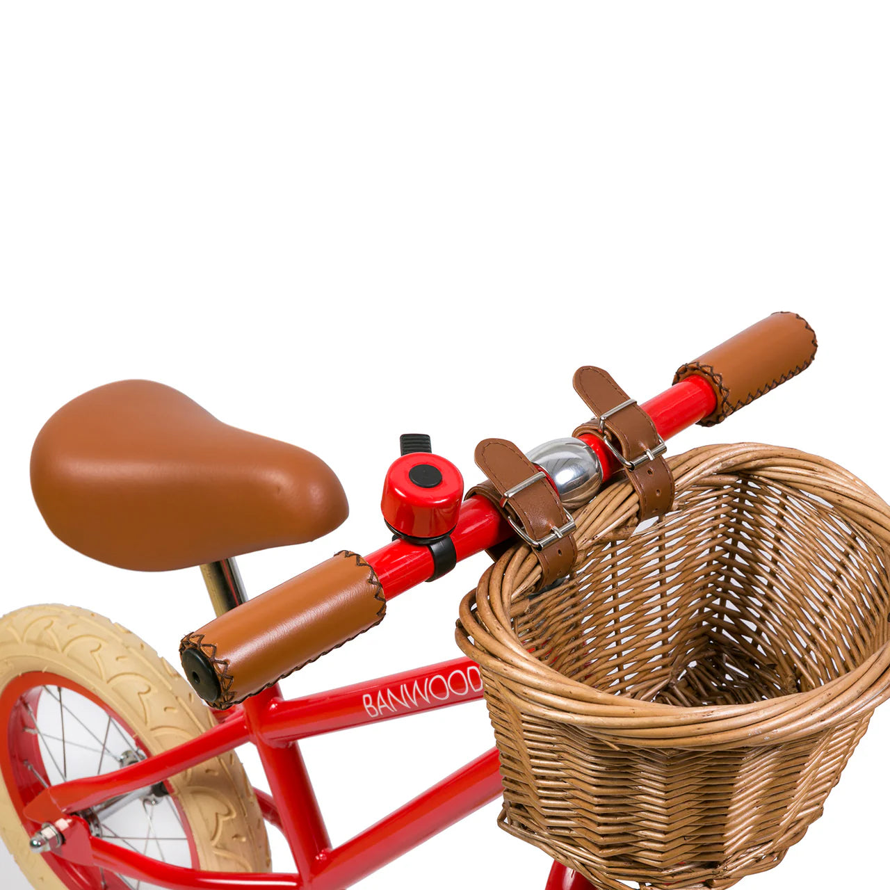 A close up of a red and black bike bell on the handle of a red banwood vintage balance bike with a straw basket.