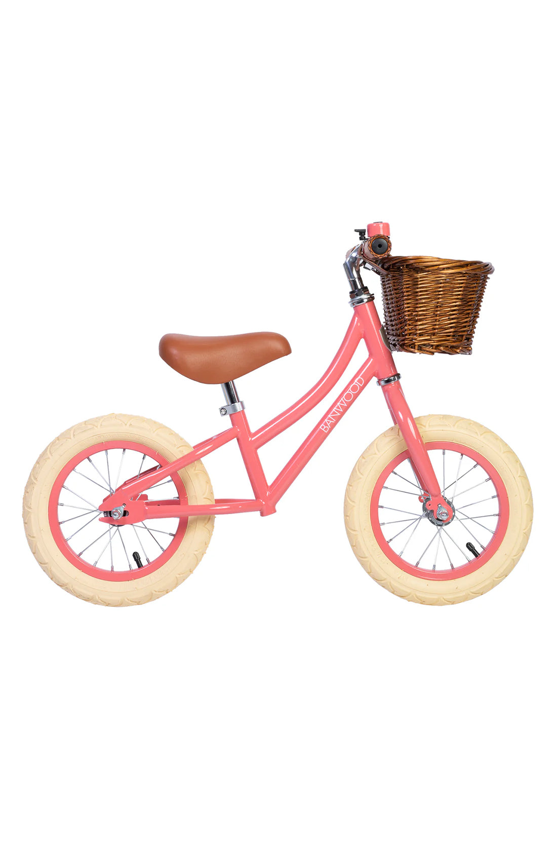 A side on shot of a coral banwood vintage balance bike with a straw basket.