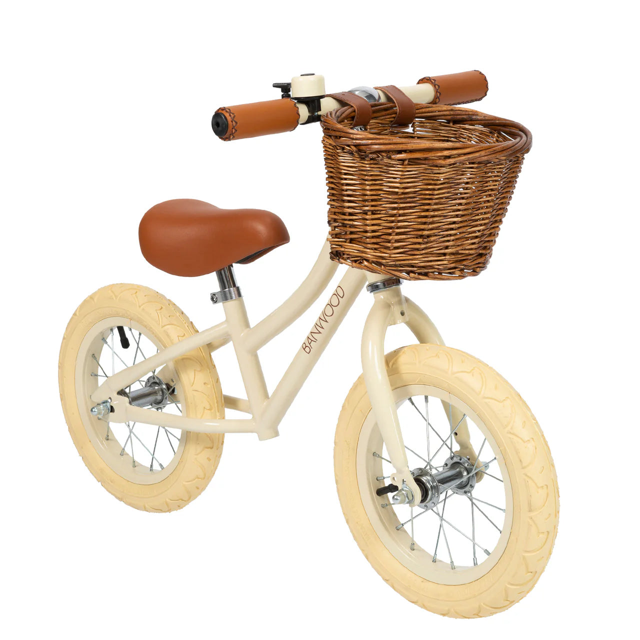 A 45 degree angle shot of a cream banwood vintage balance bike with a straw basket.