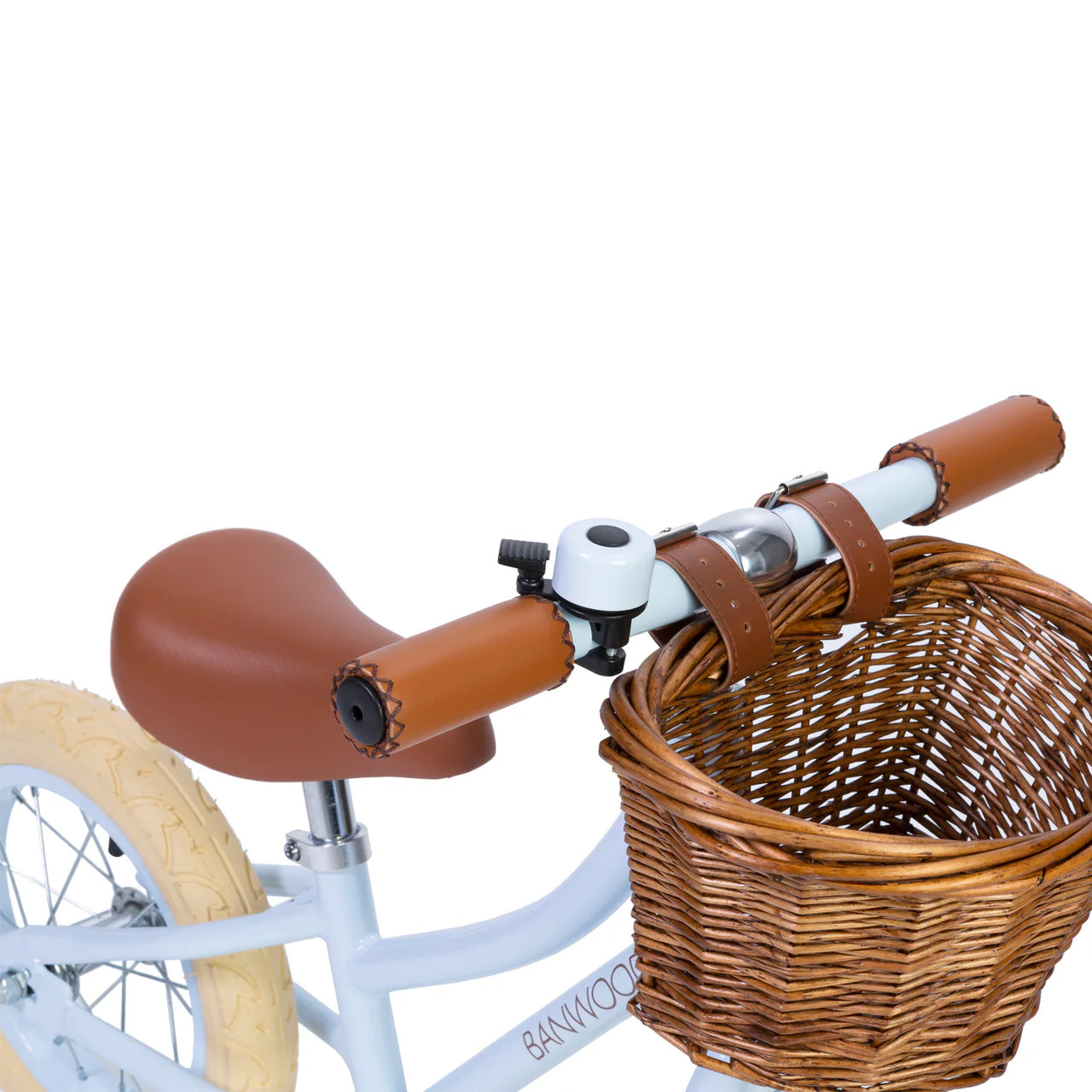 A close up of a sky blue and black bike bell on the handle of a sky blue banwood vintage balance bike with a straw basket.