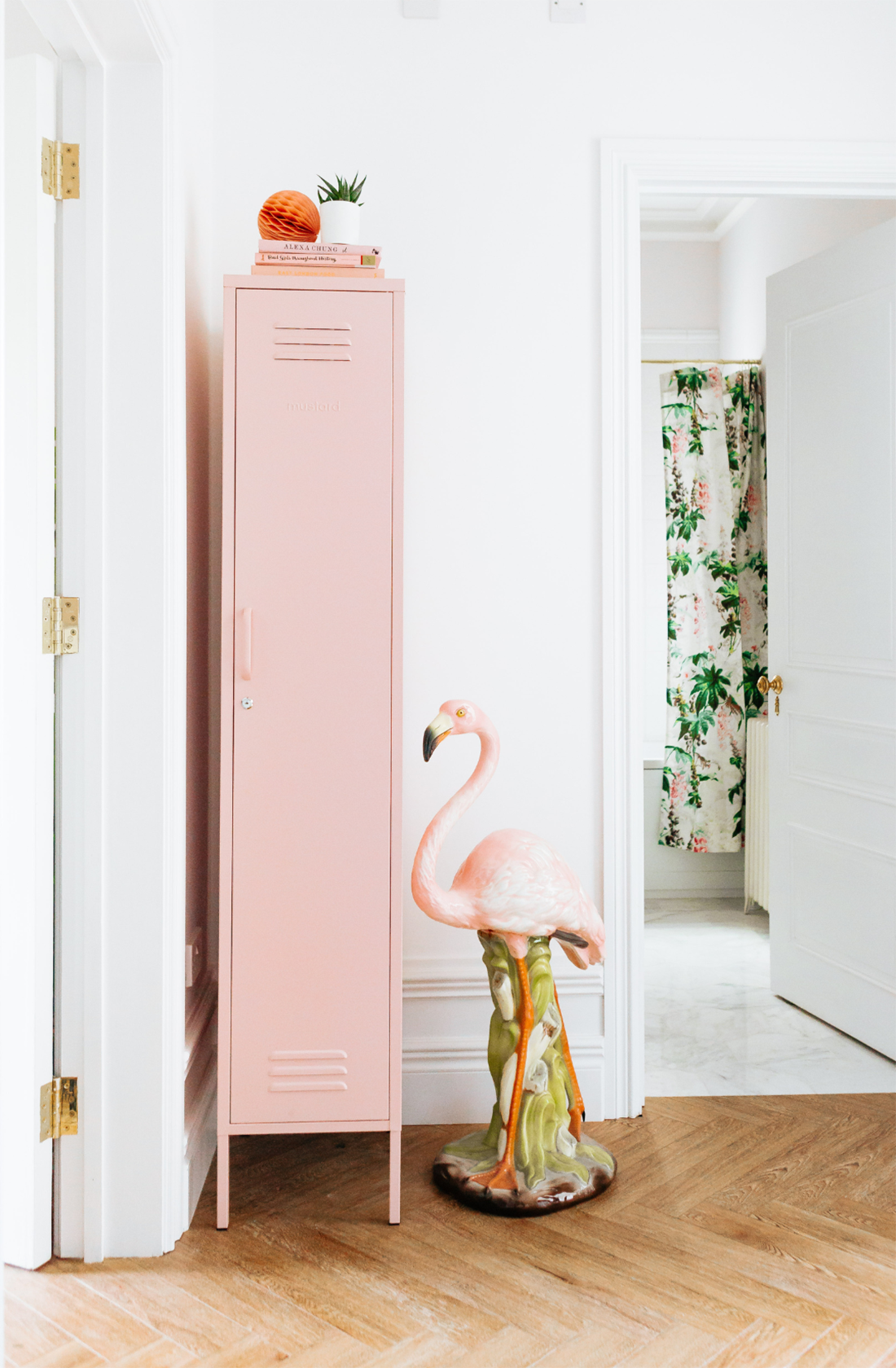 The skinny locker in blush next to a flamingo statue.