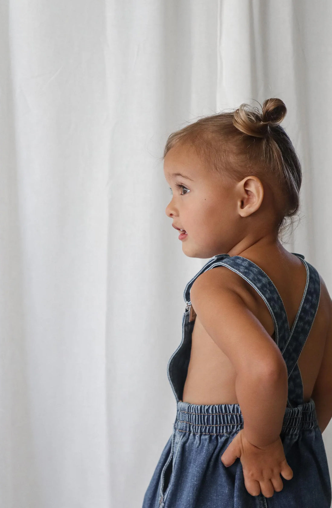 Girl with her back turned to the camera showing the back of Bowie Denim Dress