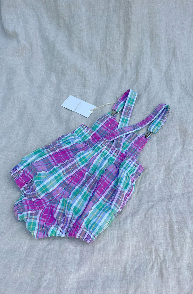 Back of Check Romper laid flat on linen background