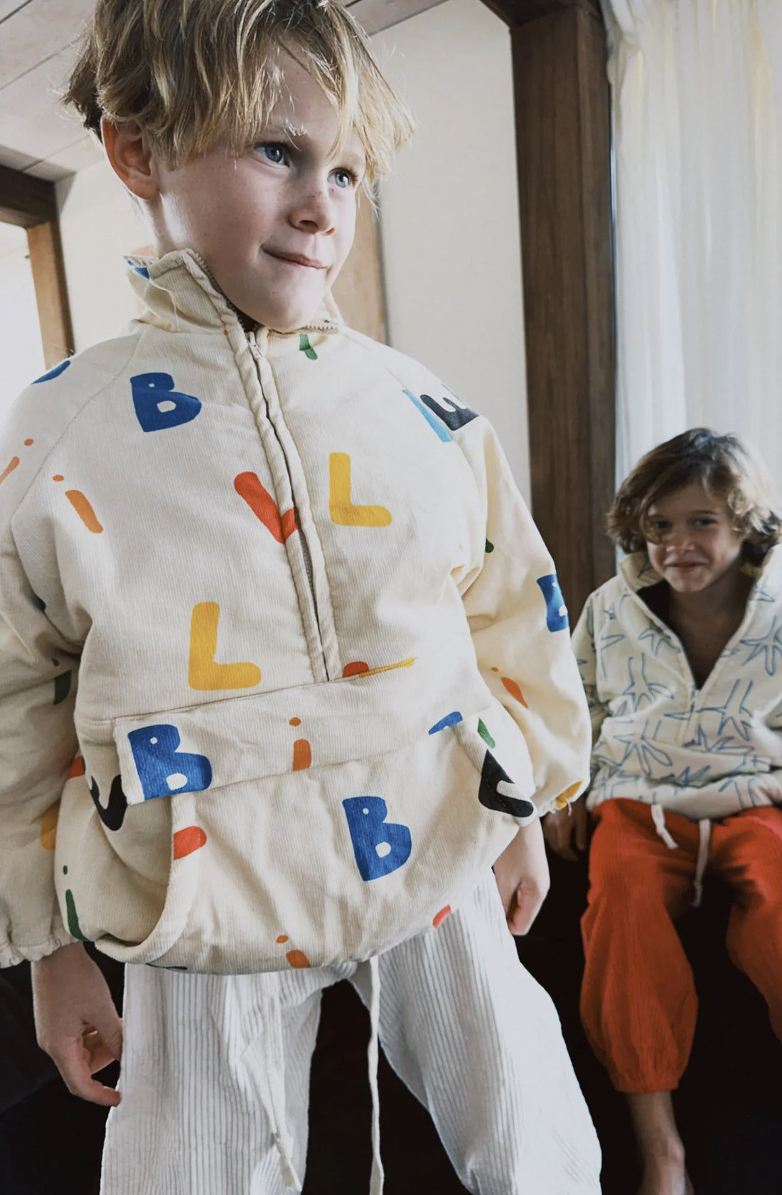 Young boy wearing the alphabet Joey jacket from By Billie.