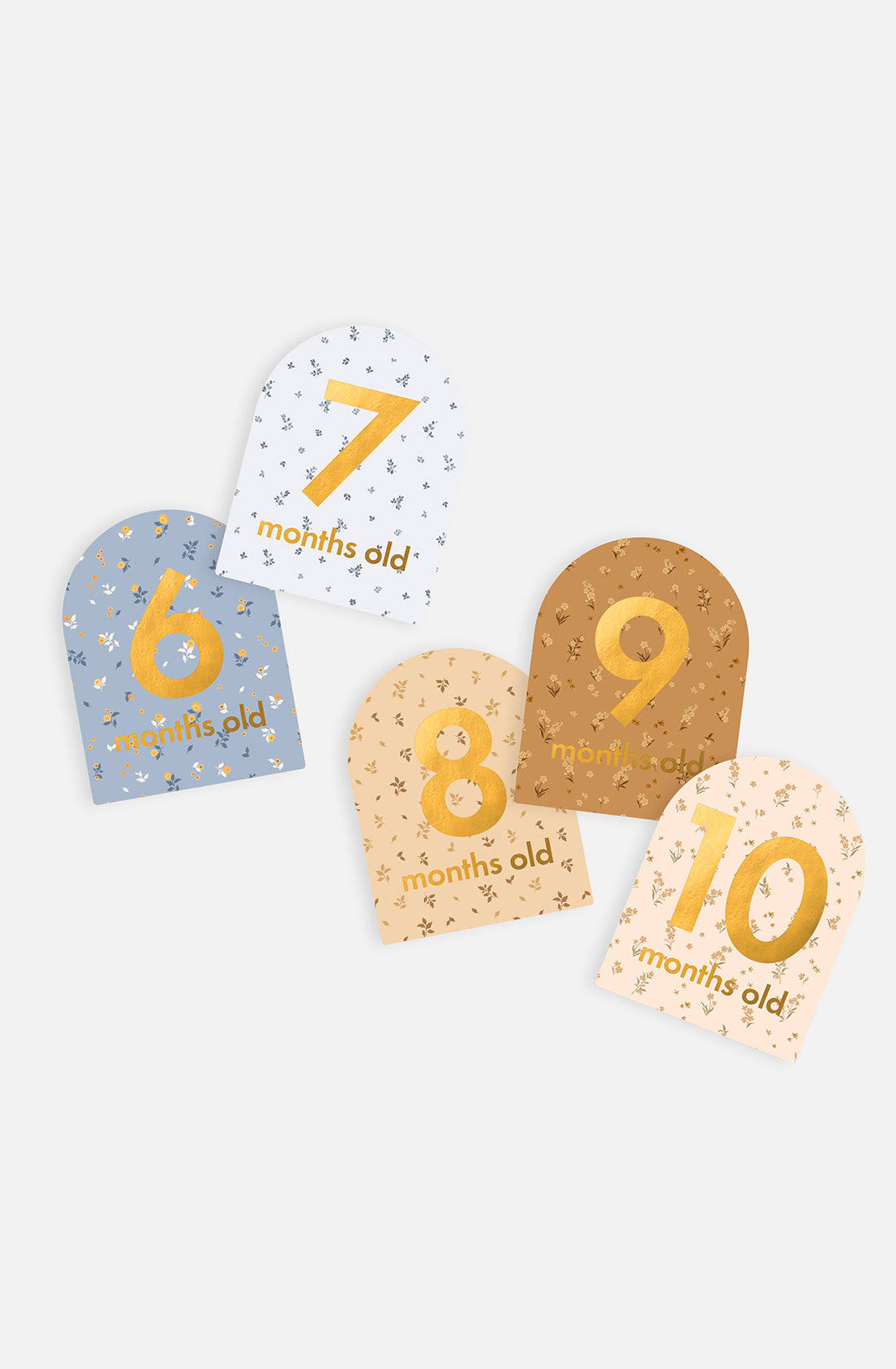 The Baby Milestone Cards Broderie by FOX & FALLOW includes five arched cards for babies, each featuring "months old" along with a number from 6 to 10. The cards come in various colors with star patterns: blue, white, beige, brown, and cream. These cards are perfect for birth announcements and commemorating important milestones.