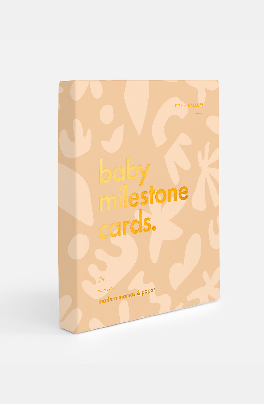 The Fox & Fallow - Baby Milestone Cards Helios features a peach box with abstract shapes from the Helios Collection. The text says, "baby milestone cards. for modern mamas & papas." Brand: FOX & FALLOW.
