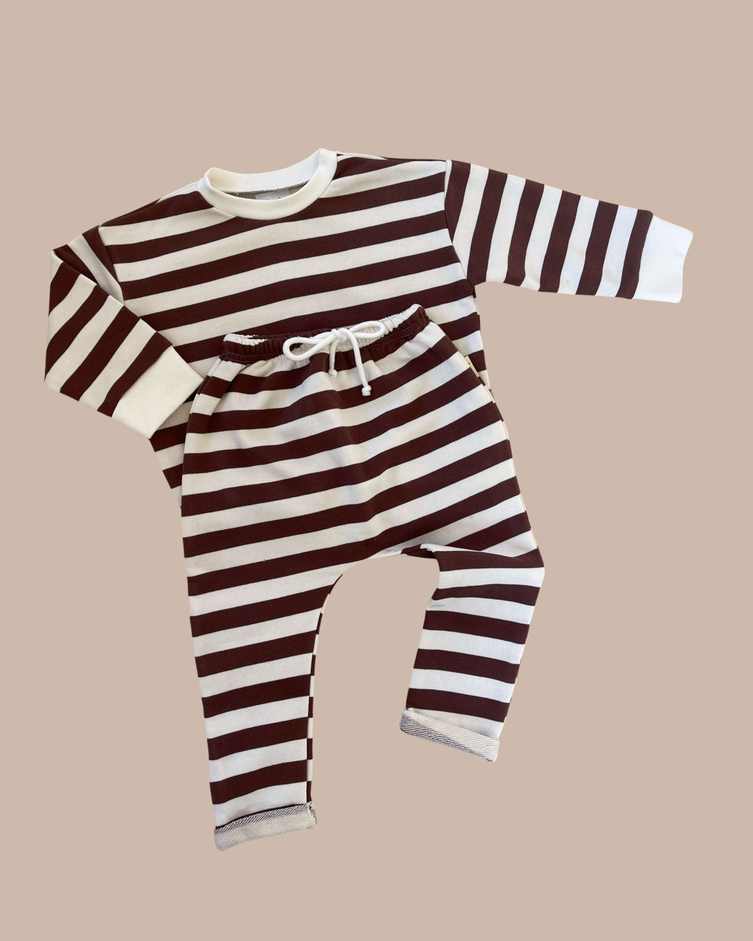 Chocolate brown striped pullover and matching pants on a light brown background.