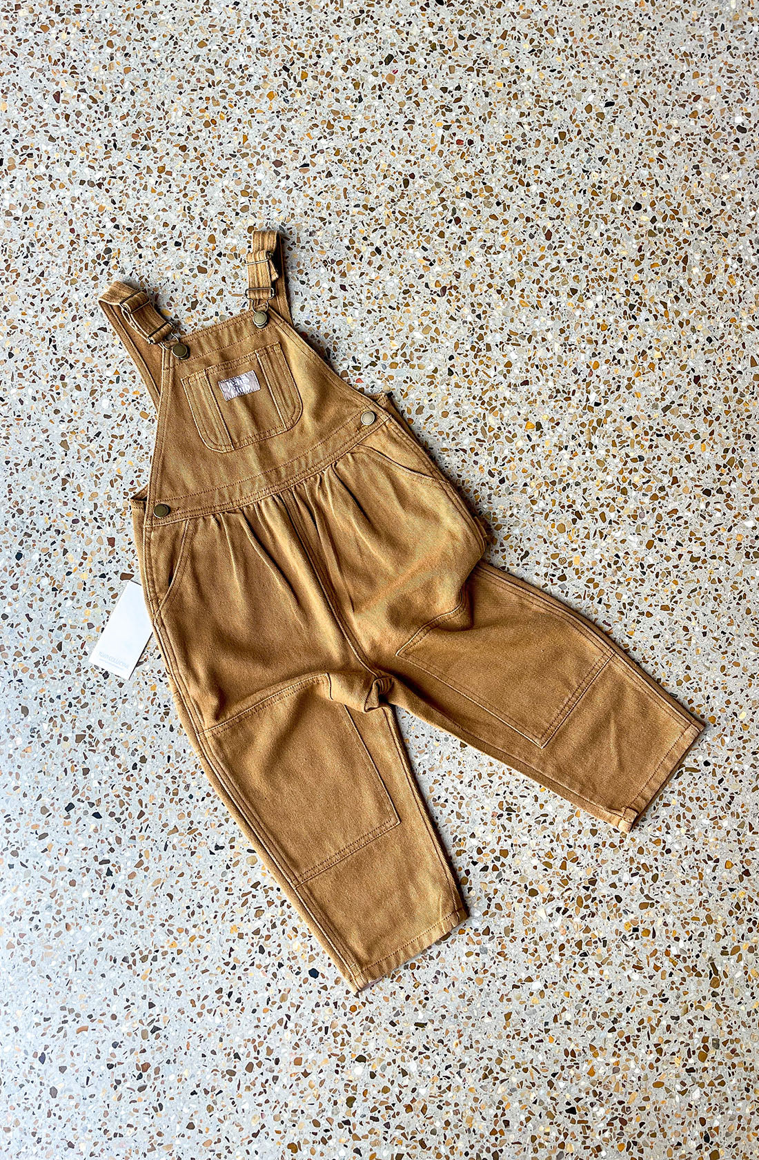 Carpenter overalls laid flat on concrete floor