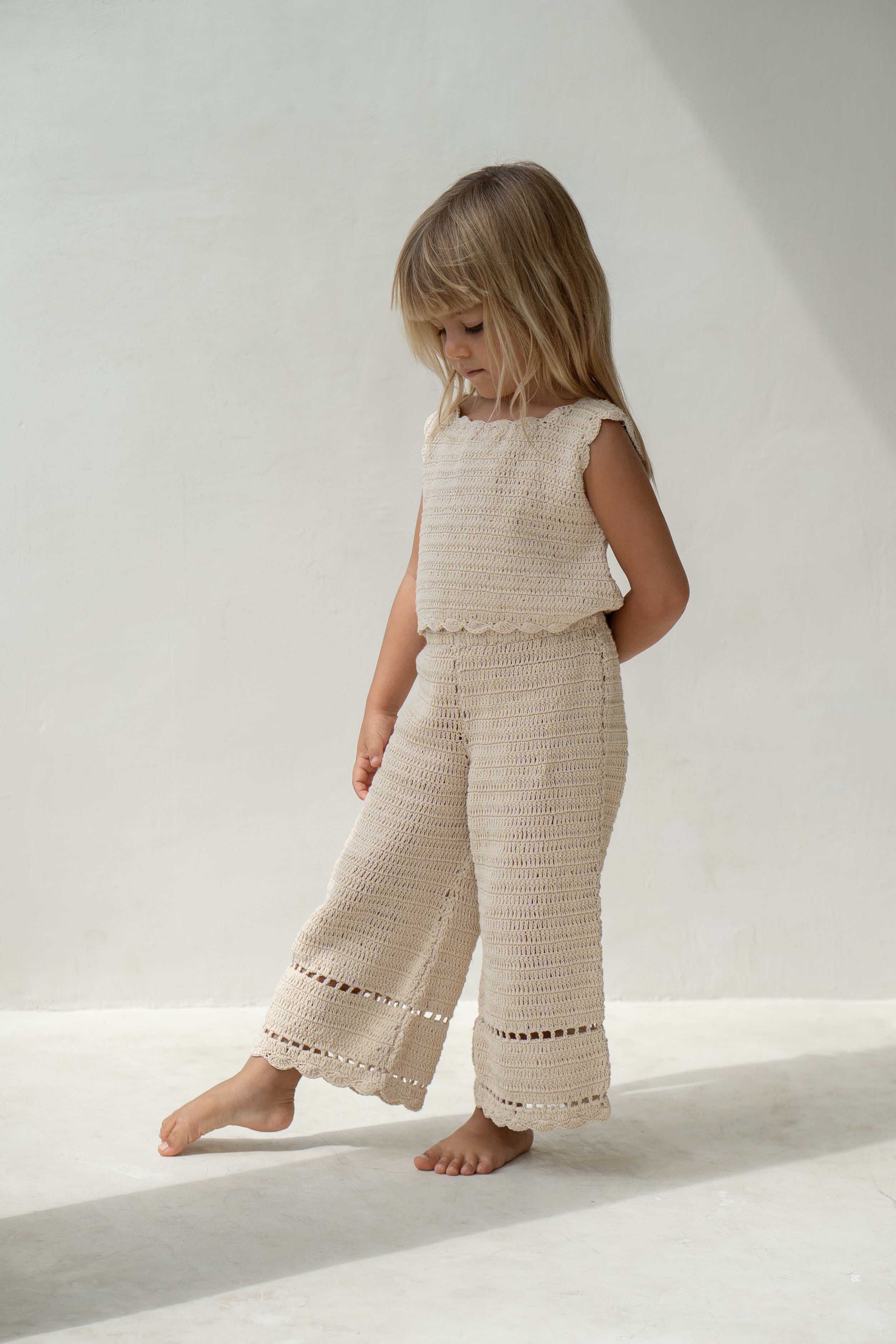 Young girl wearing the crochet pant in ecru with matching vest.