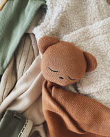 Teddy cuddle blanket cuddled into pile of cozy clothing