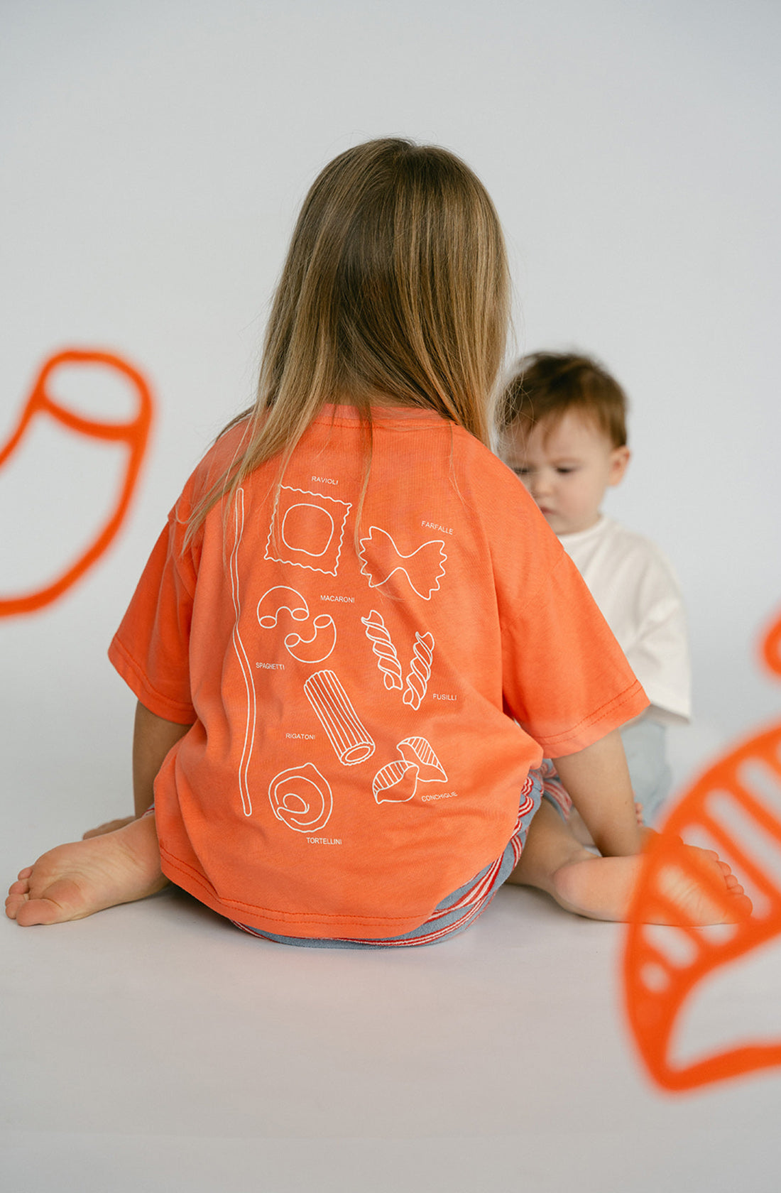 The back of a young kid wearing the Lenn pasta tee.