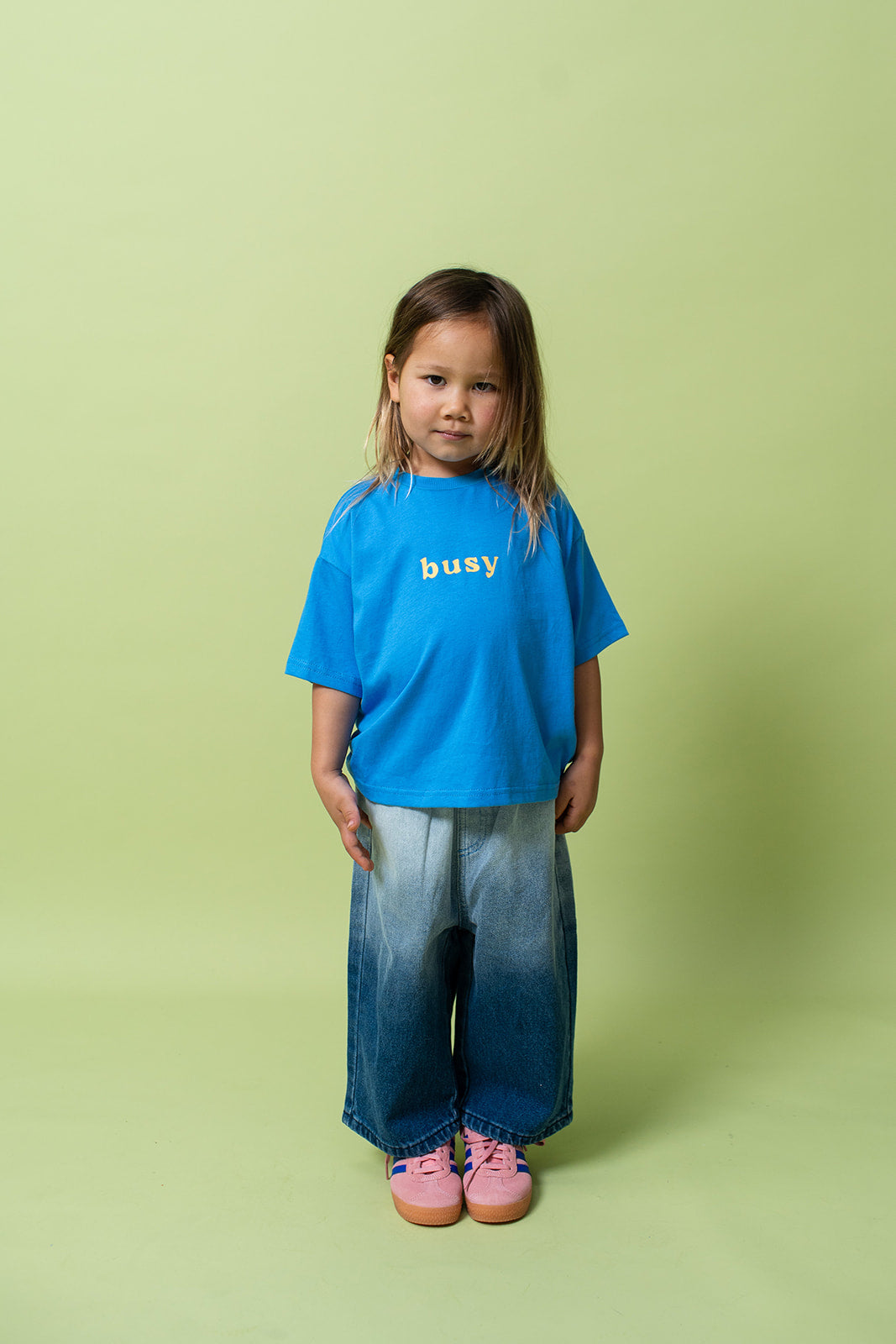 A young kid wearing the Lenn busy tee sunny shirt in blue.