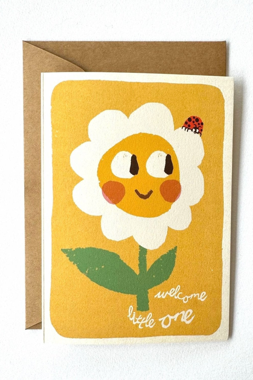 The FLORENCE FRY "Welcome Little One" New Baby Greeting Card features a smiling daisy and red ladybug, with white script text. Includes a recycled Kraft envelope.