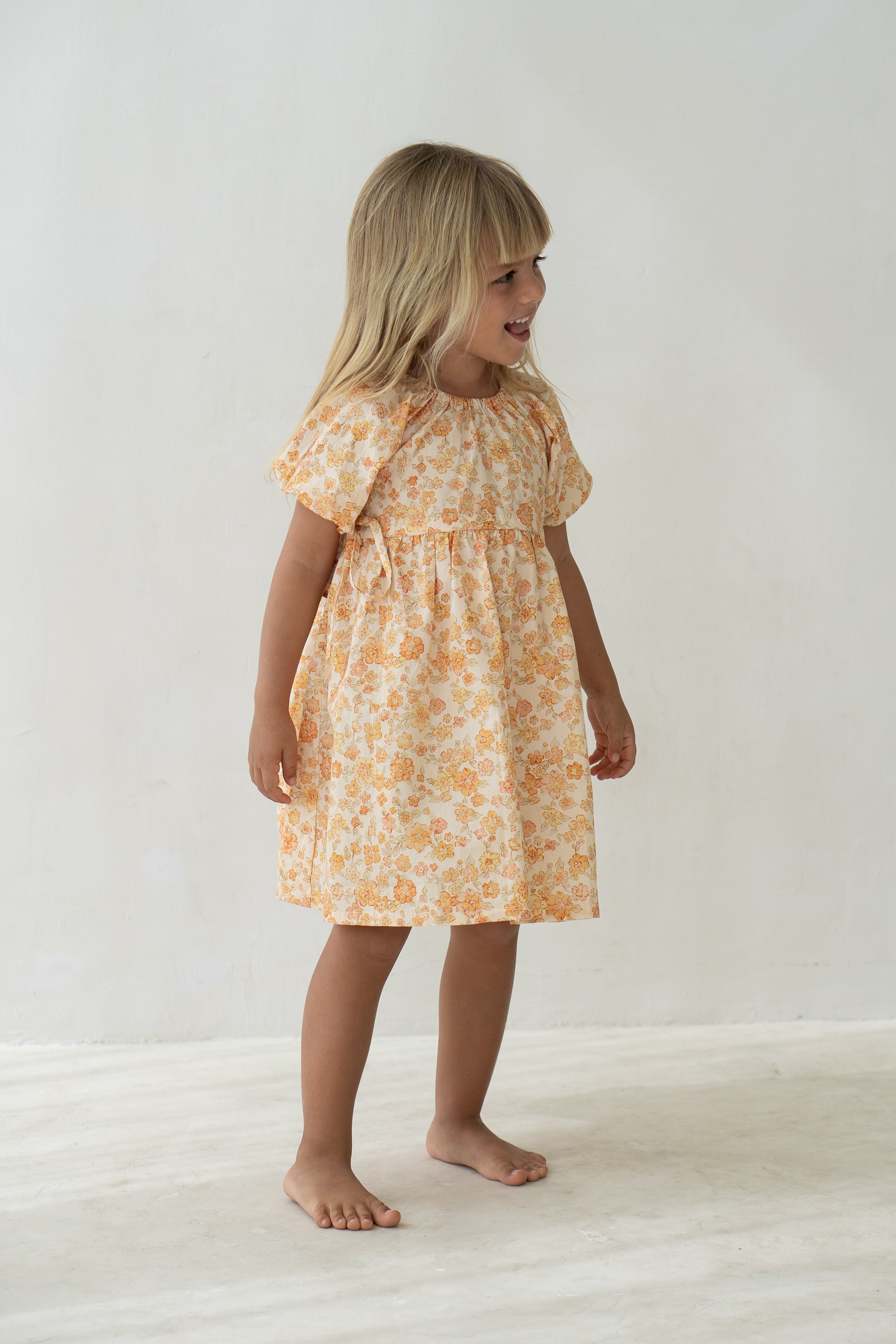 Young girl wearing the florence dress in buttercup.