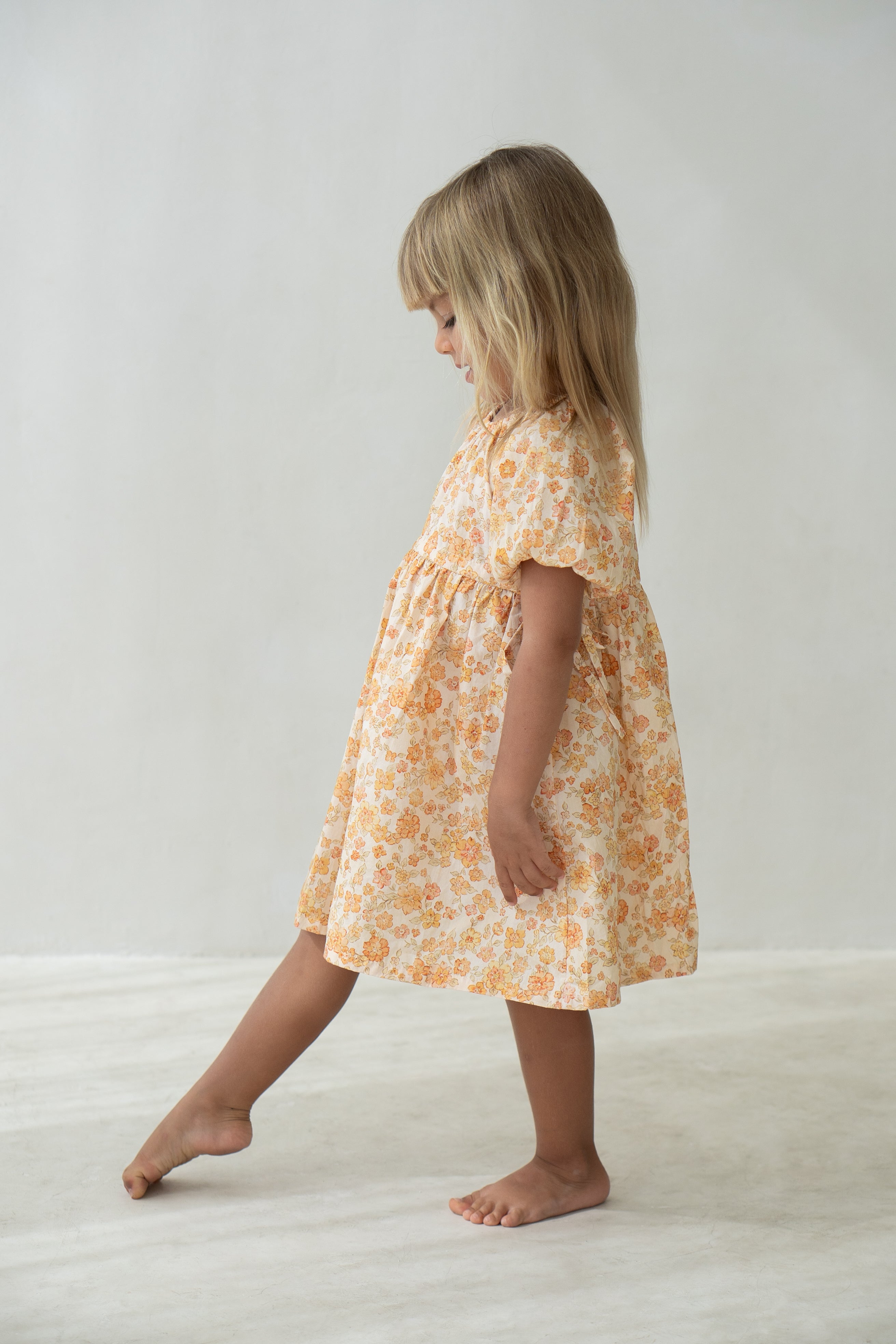 Young girl wearing the florence dress in buttercup.