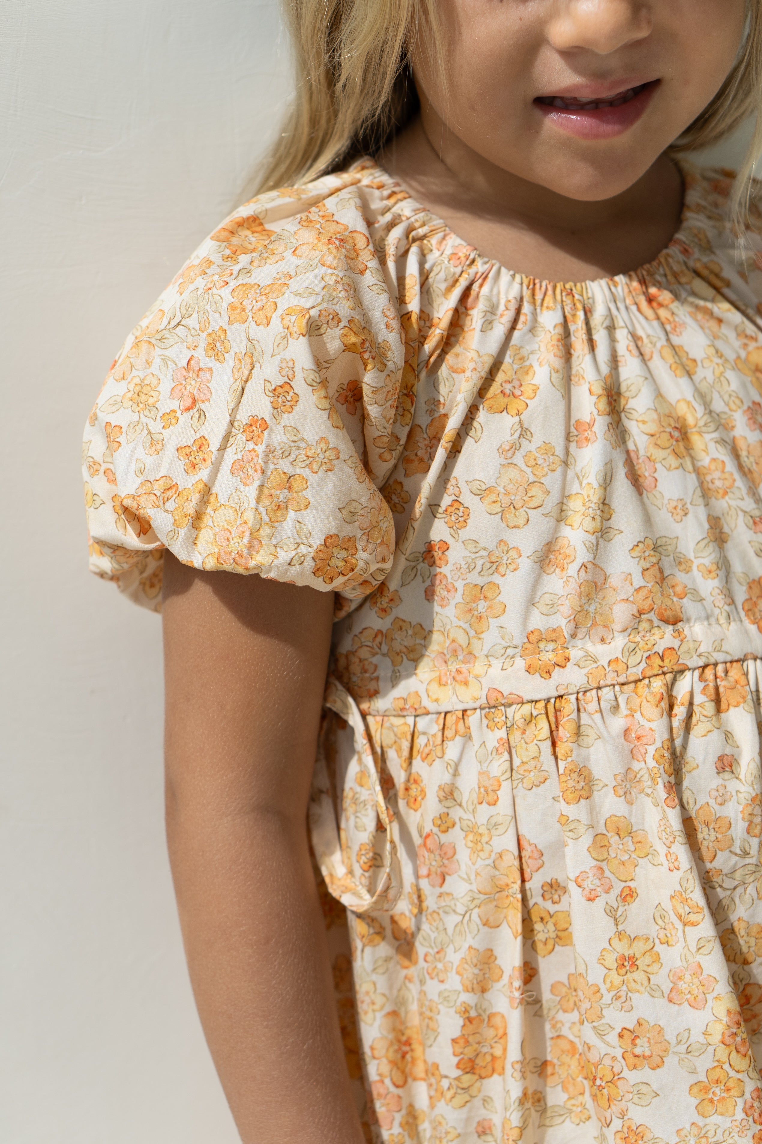 Young girl wearing the florence dress in buttercup.