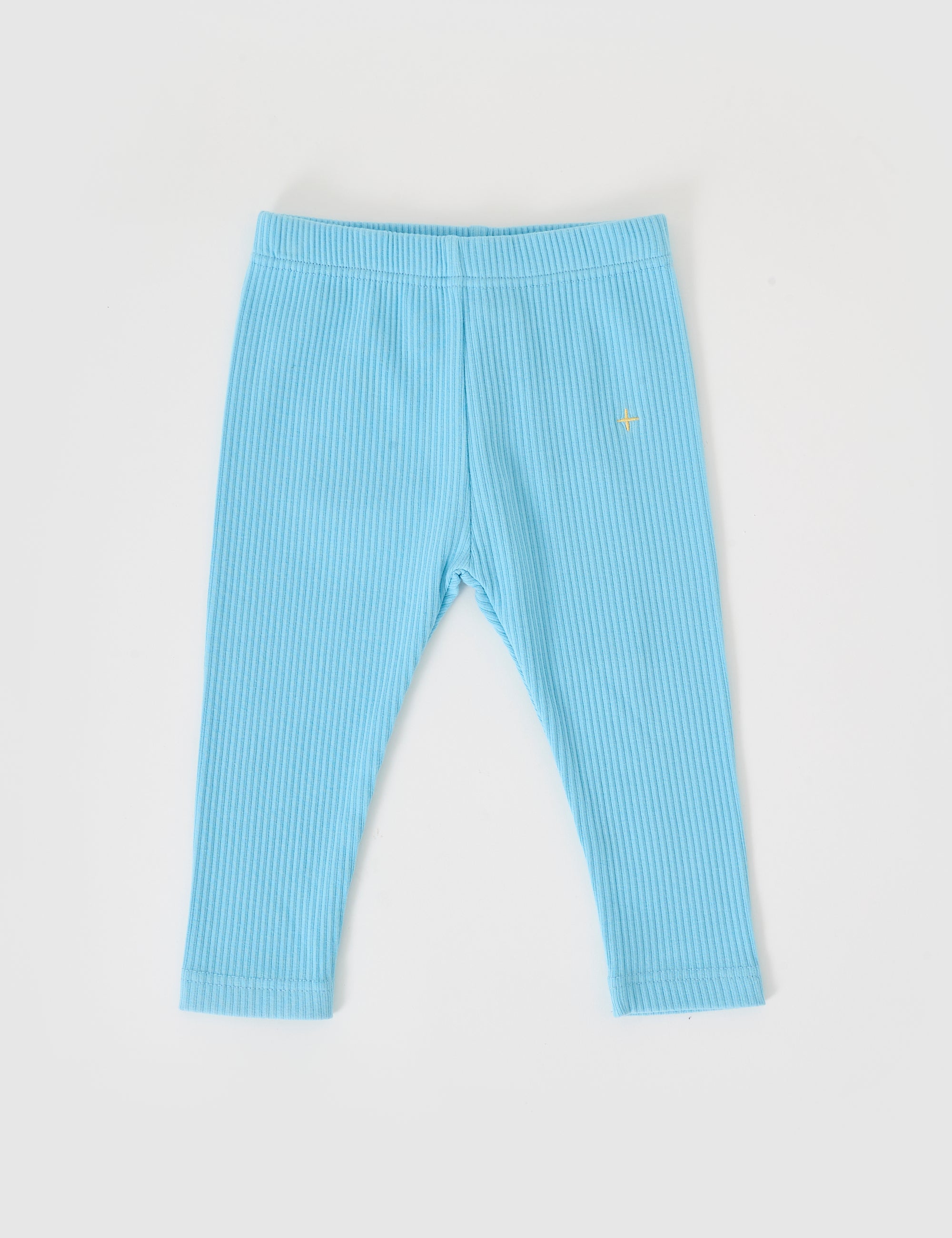 The Goldie + Ace Bowie Rib Legging in Sky Blue, by GOLDIE + ACE, is showcased flat on a white background. Featuring a small yellow star emblem on the left hip, these cotton elastane leggings with an elasticated waist offer stretch, comfort, and style.