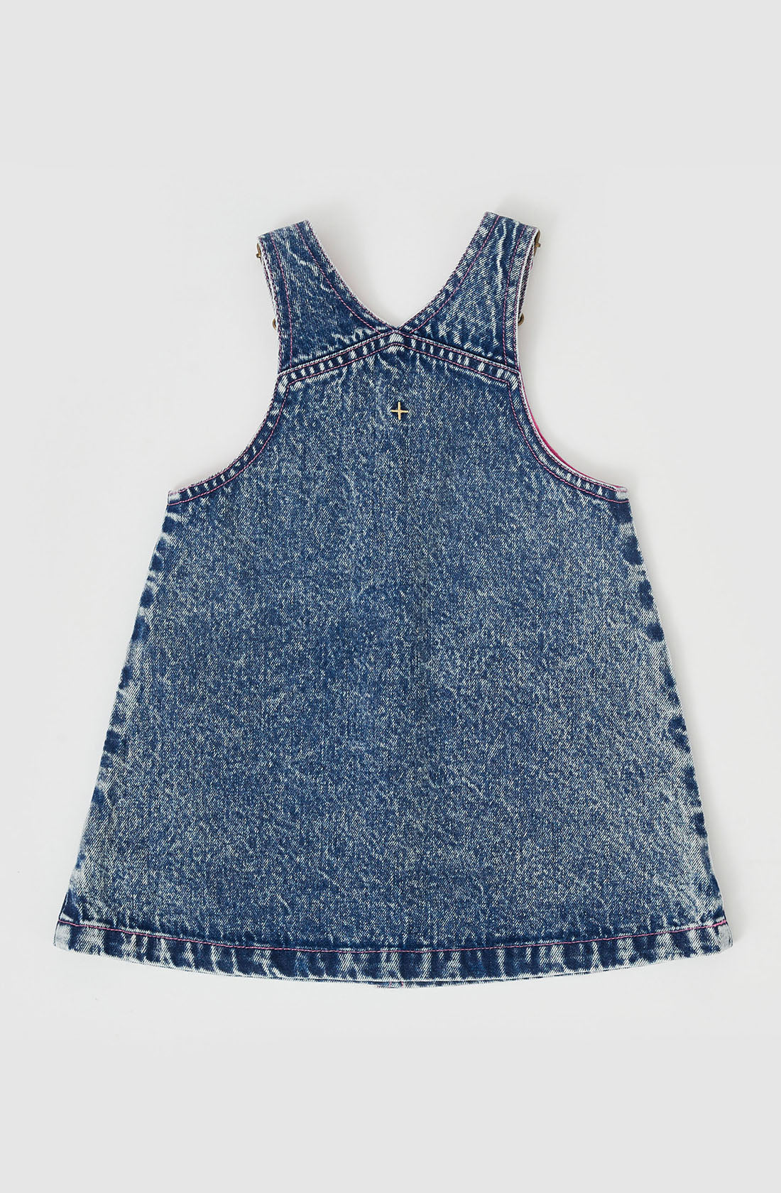 Introducing the Penelope Fruity Denim Pinafore Dress by GOLDIE + ACE, a stylish dark denim piece with a simple, sleeveless design. It features contrast stitching along the edges and hand-drawn embroidery on the pockets for a unique touch. With adjustable brass straps and a slightly flared silhouette, this dress exudes a distinctly vintage charm.