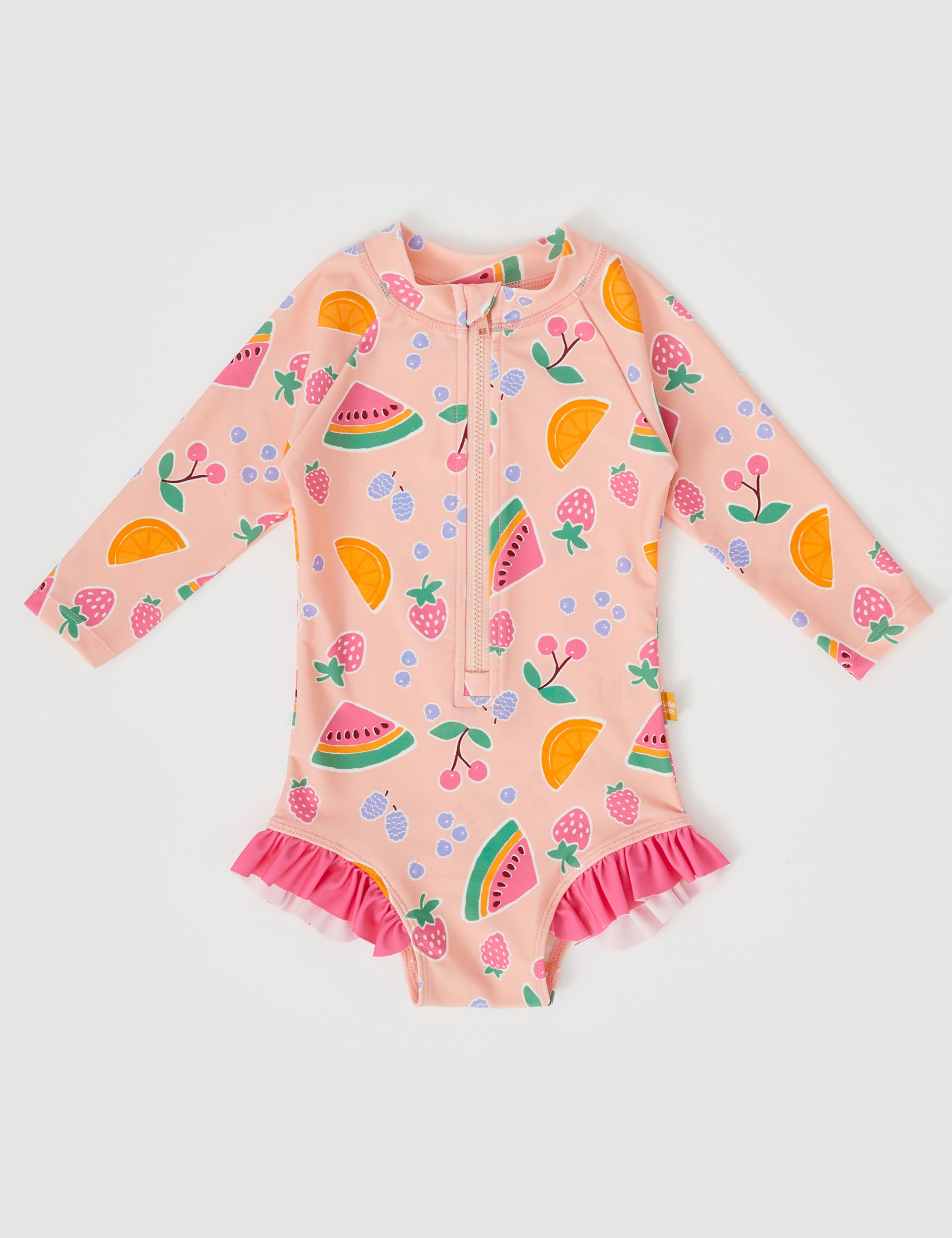 Introducing the Fruit Salad Long Sleeve Swimsuit by GOLDIE + ACE: a vibrant children's swimsuit adorned with hand-drawn fruit graphics, showcasing watermelons, oranges, cherries, strawberries, blueberries, and leaves. This light pink swimsuit offers SPF protection and features a front zipper along with ruffled trim at the leg openings.