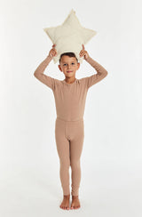 Boy standing with star cushion above his head wearing the sleep set in tawny brown