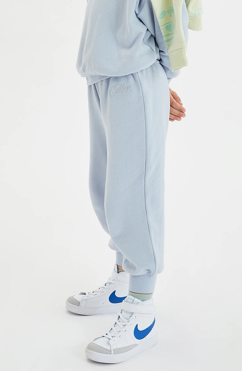 Close up of boy wearing a pair of pale blue tracksuit pants with white Nike sneakers
