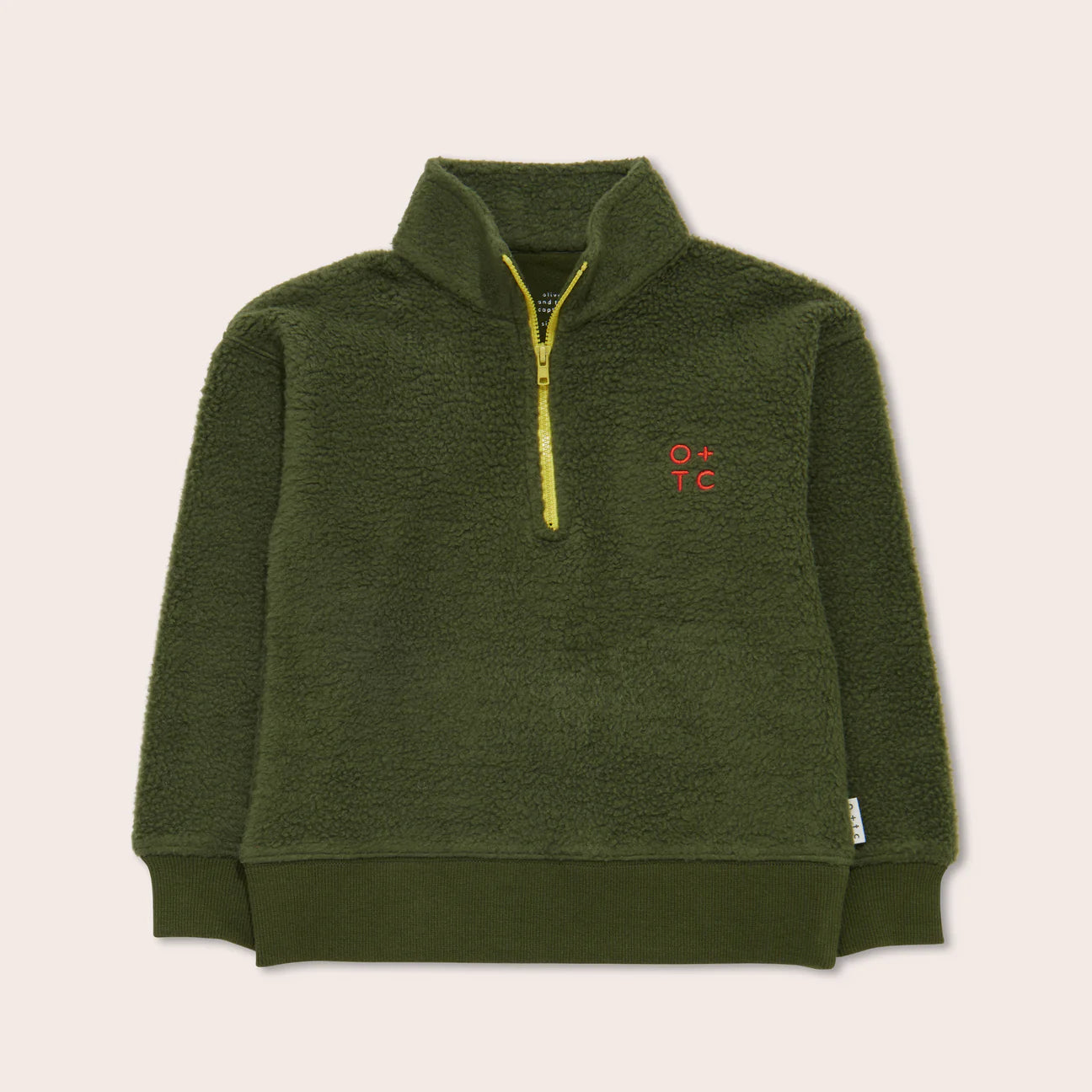 Presenting the Olive Zip Pullover from OLIVE + THE CAPTAIN, this vibrant yellow fleece pullover features a half-zip design. Adorned with an embroidered "O + T C" in red on the left chest, this 90's inspired piece boasts a ribbed hem and wrist cuffs for added texture contrast. Ethically made from premium cotton, it combines both style and comfort seamlessly.