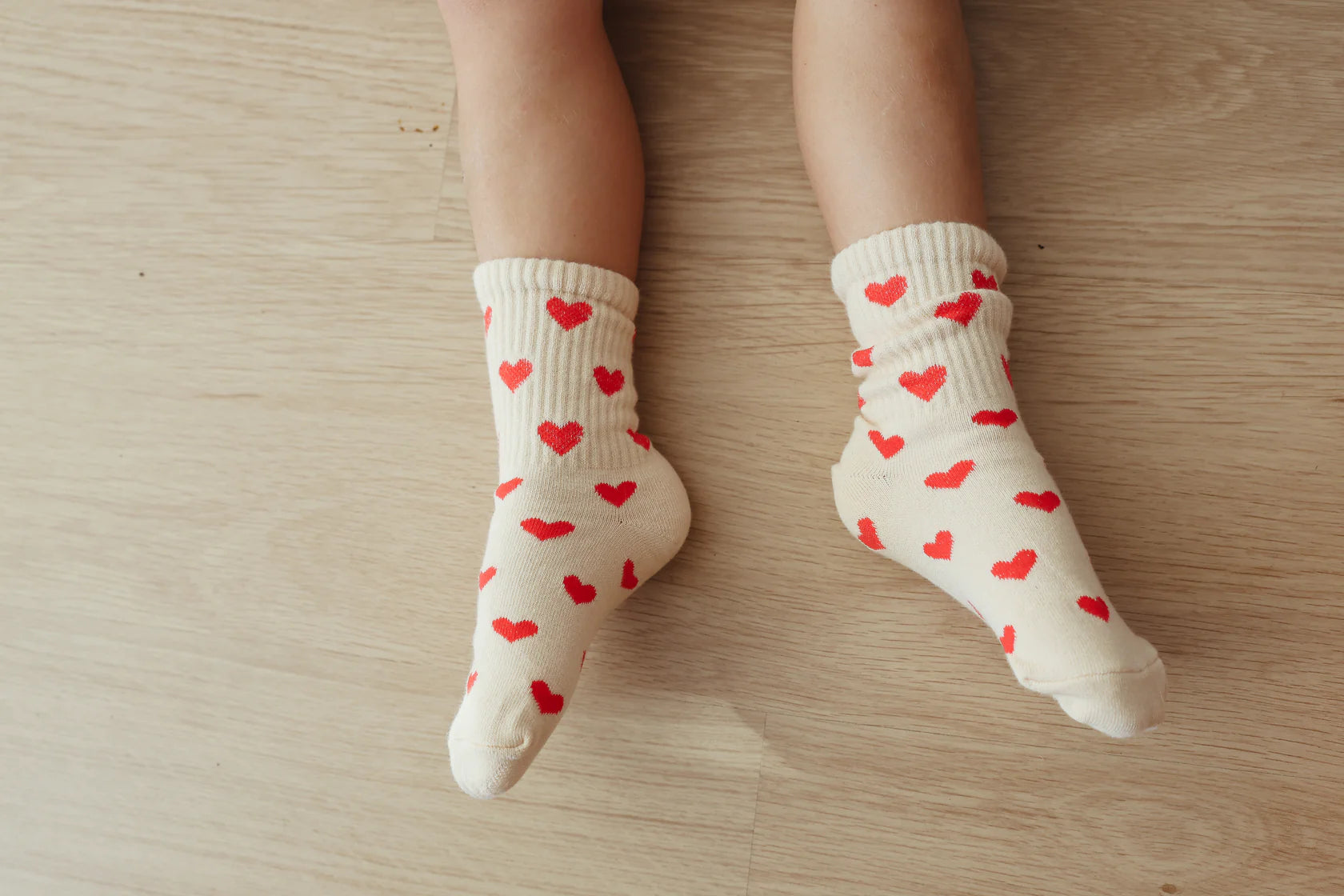 A little kid wearing the all heart socks.