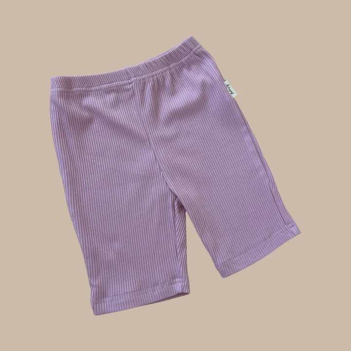 Bubblegum Bike Shorts by BOBBY G BABY WEAR, a summer essential, rest stylishly on a beige background.