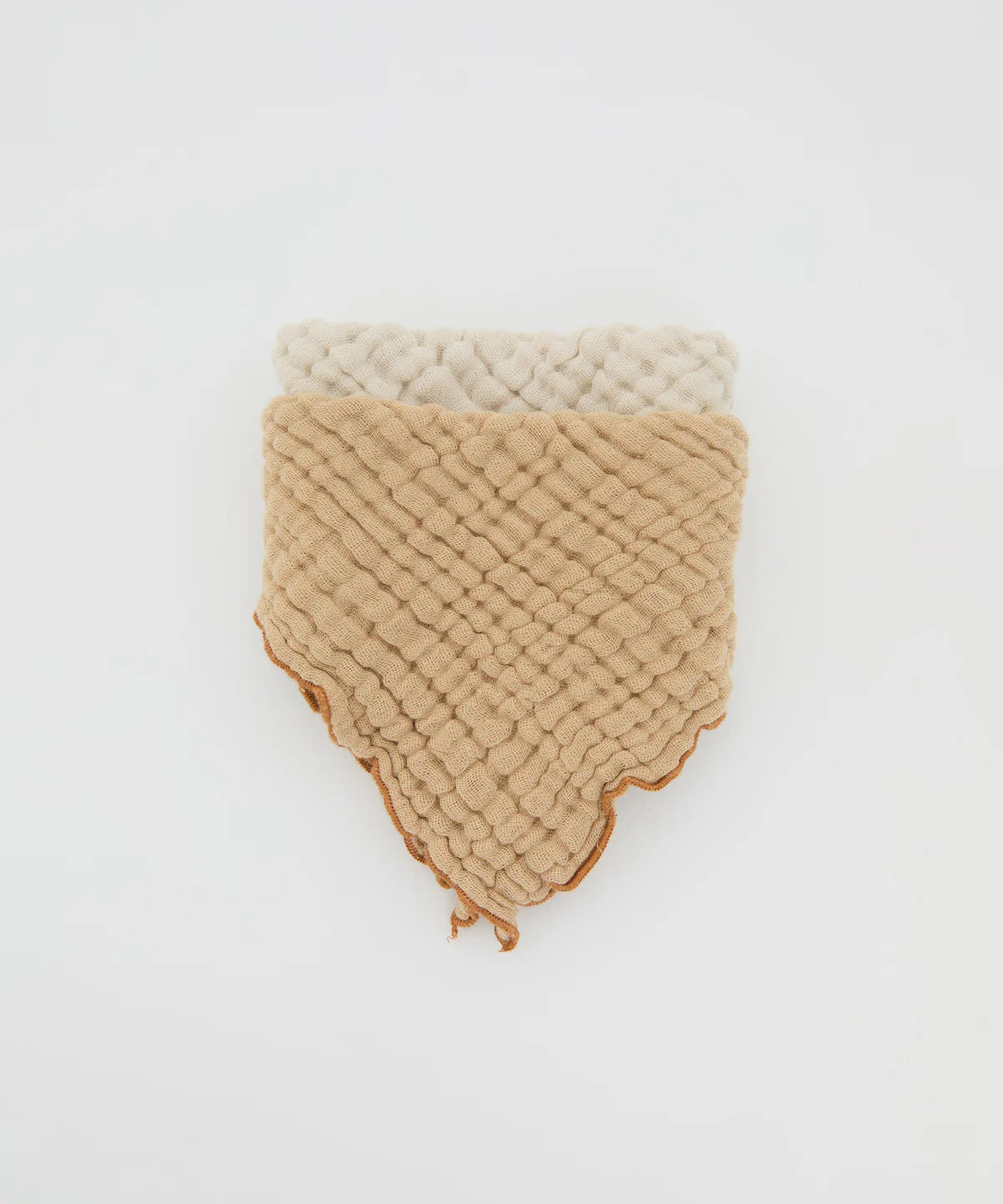 Two textured, diamond-shaped cotton bibs—one beige, one off-white—from PHILÉ’s Philé - Cotton Bib Double Pack Cacao rest on a plain white background. OEKO TEX® certified, they feature scalloped edges, a quilted pattern, and a subtle bandana design.