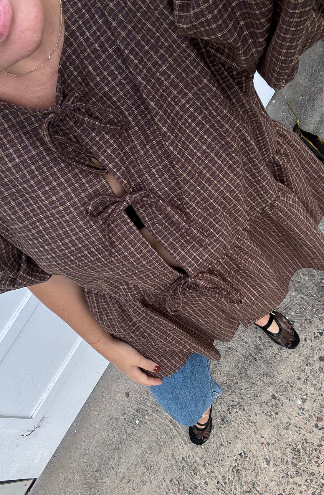 A women wearing the mama cami blouse and jeans.