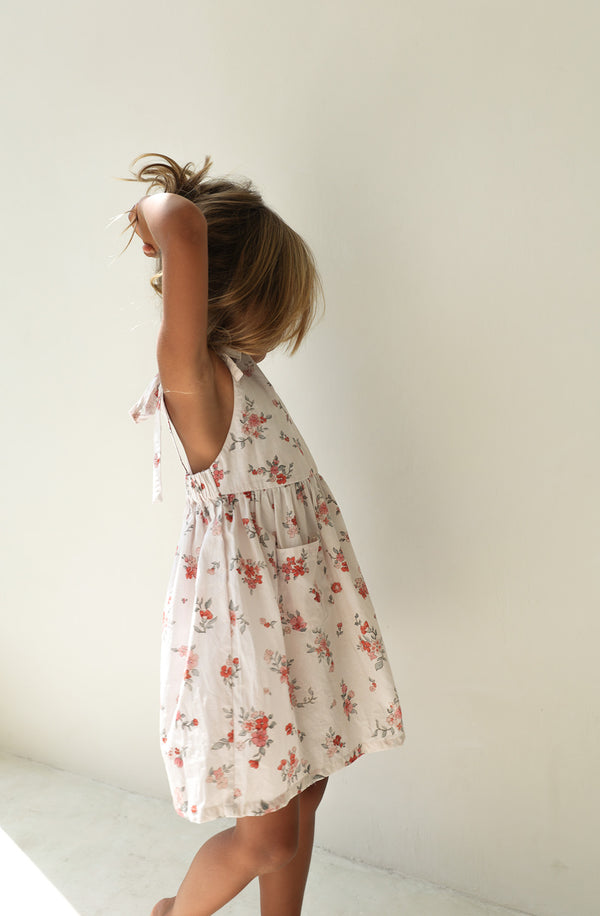 Girl standing on the side wearing the Luna Pinafore