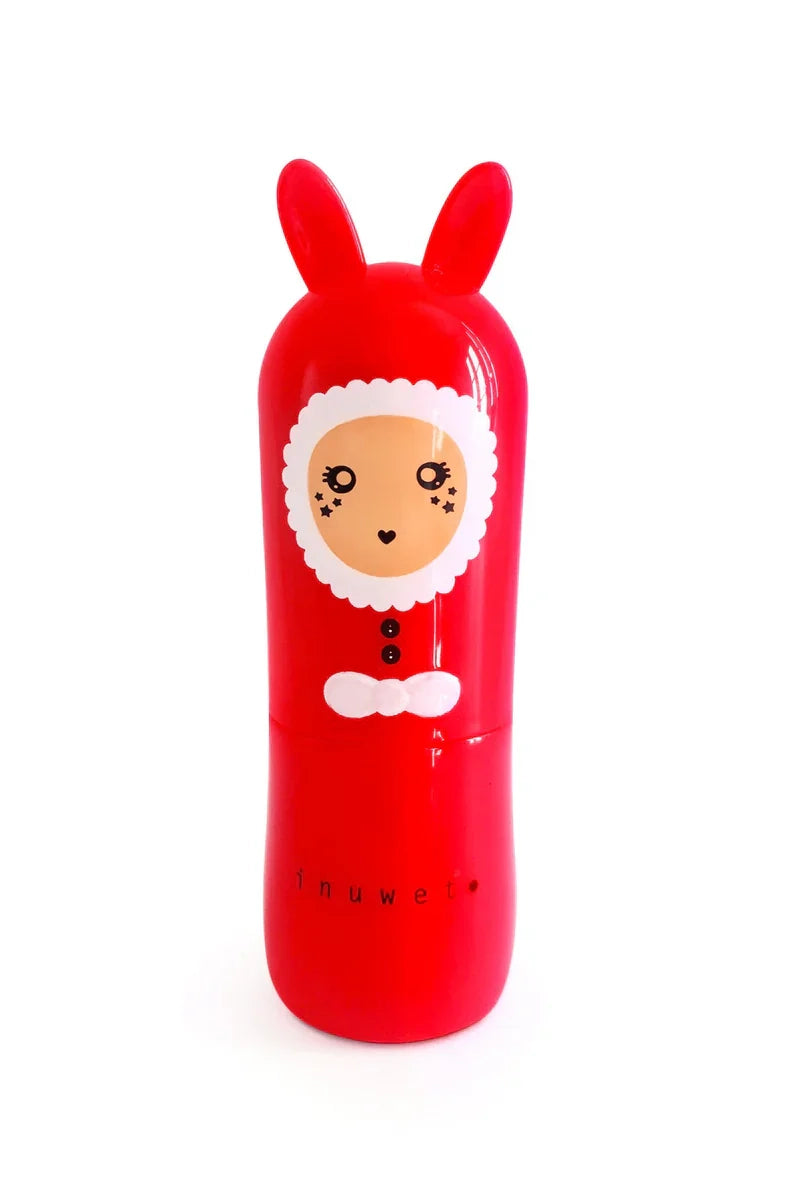 Against a white background, the Christmas Lip Balm Mango by INUWET is showcased in an adorable red, rabbit-shaped container. It features charming star-shaped eyes and a playful button design, topped with a white, fluffy hood. This vegan and cruelty-free balm offers a delightful mango scent.