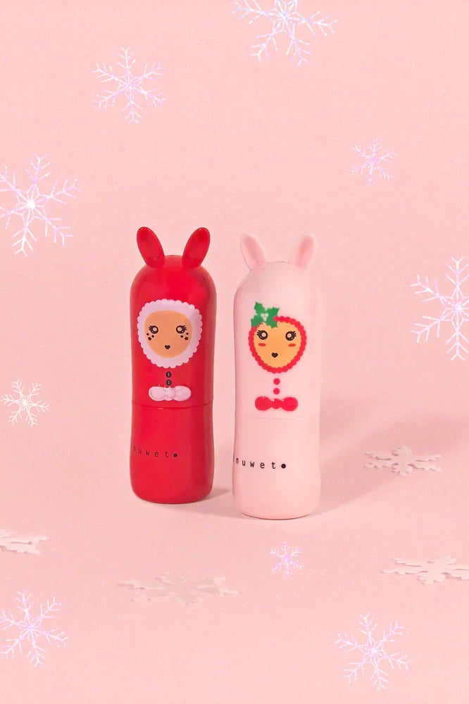 The Christmas Lip Balm Candy Cane set by INUWET features two delightful tubes: one in a red design with reindeer antlers and a charming face, and the other in a white theme with bunny ears. Made from natural ingredients and cruelty-free, these lip balms are presented against a pink backdrop decorated with white snowflakes, making them perfect for spreading holiday cheer!