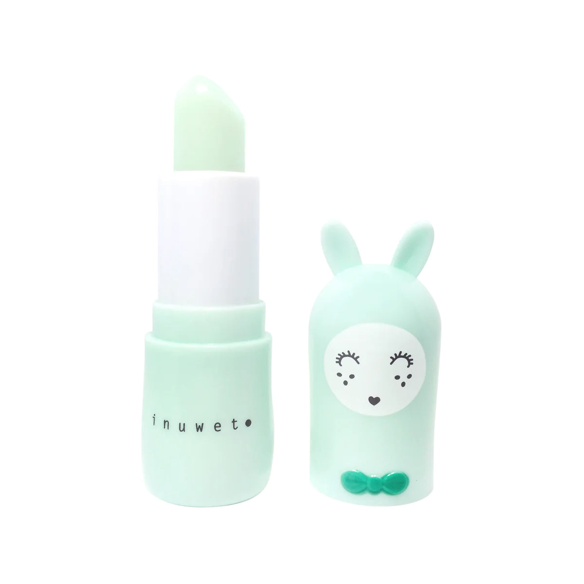 A light green lipstick tube with the cap removed, revealing a cute character with bunny ears, closed eyes, a heart-shaped nose, and two small dots on its cheeks. Infused with shea butter for smooth application, the cruelty-free "INUWET Bunny Lip Balm Apple" is printed in lowercase letters on the tube.