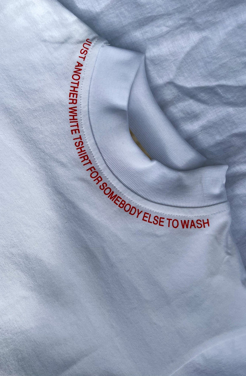 Close up of 'Just Another t-shirt for somebody else to wash' print around the neckline of a white t-shirt