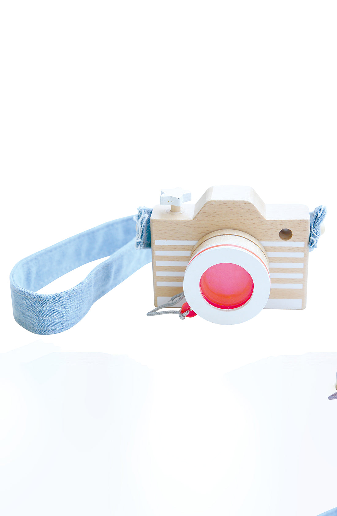 The KIKO & GG Kaleidoscope Play Camera Pink is a wooden camera adorned with a light blue fabric strap. This toy photographer's delight showcases a light-colored wooden body featuring horizontal white lines on the front and is accented with a red circular lens at the center. The strap is attached to the top, wrapping around to one side for easy carrying.