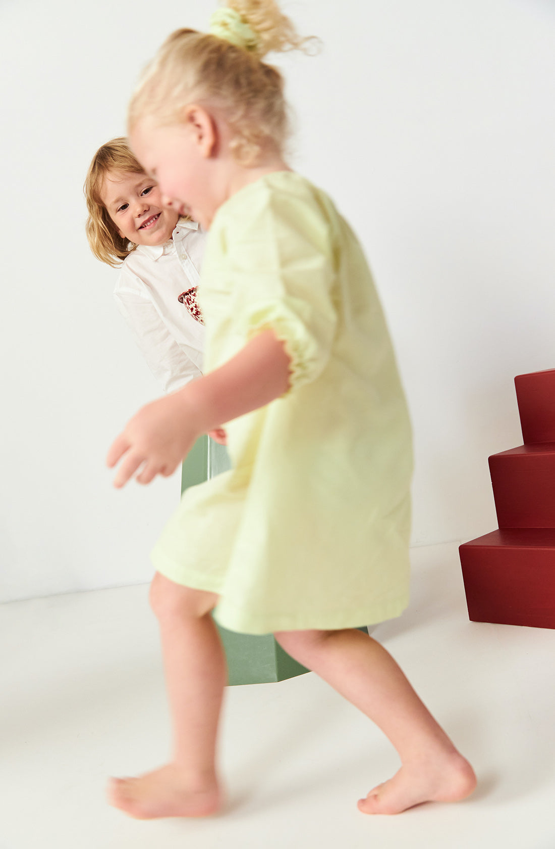 Blonde girl running in a studio while wearing the Run to the Sun dress