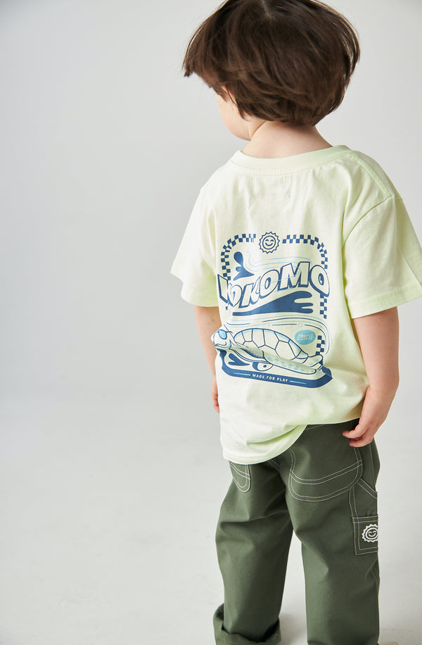 Boy facing backwards to show the turtle print on the back of the Cruisin tee