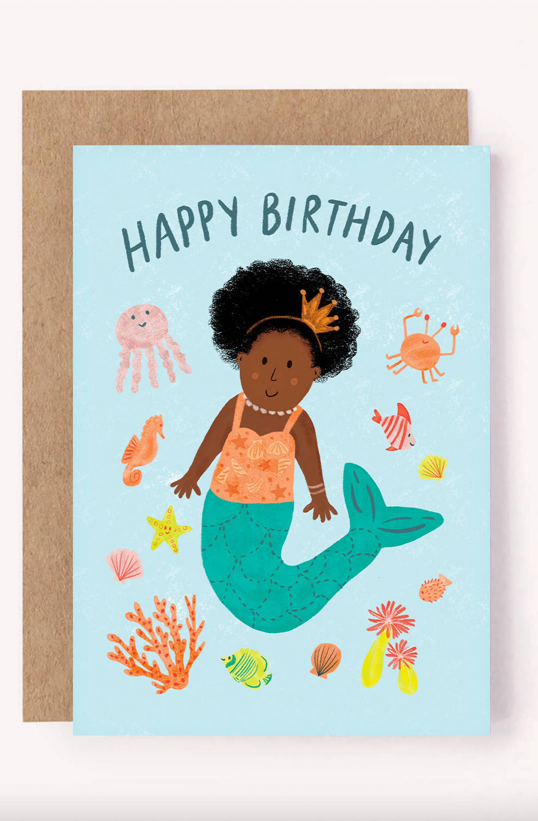 On the LAUREN SISSONS STUDIO Birthday Greeting Card Mermaid "Happy Birthday," a cheerful mermaid with a crown is surrounded by sea creatures such as a jellyfish, crab, starfish, colorful fish, and corals. Crafted from recycled paper, this mermaid-themed greeting card features a "Happy Birthday" message at the top against a light blue background.