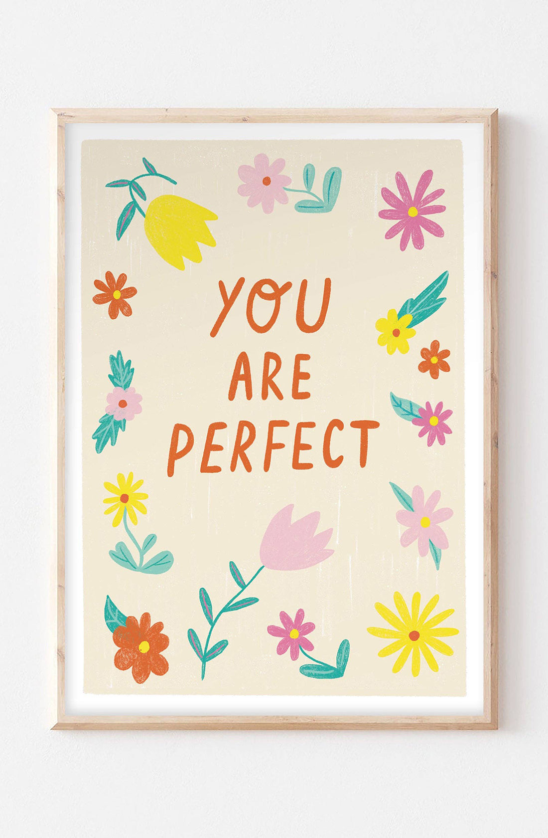 An art print with the words "you are perfect" on it with yellow pink and red flowers surrounding it, designed by Lauren Sissons