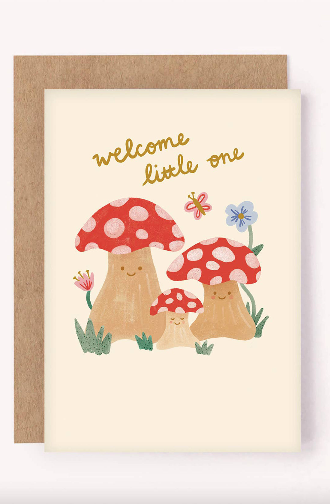 Introducing the "New Baby Greeting Card 'Welcome Little One' Mushrooms" from LAUREN SISSONS STUDIO: a gender-neutral card featuring an illustration of three cheerful mushrooms with red and white caps, surrounded by flowers. At the top, the message "welcome little one" is elegantly written in yellow cursive. Crafted from recycled paper, this charming card comes with a brown envelope.