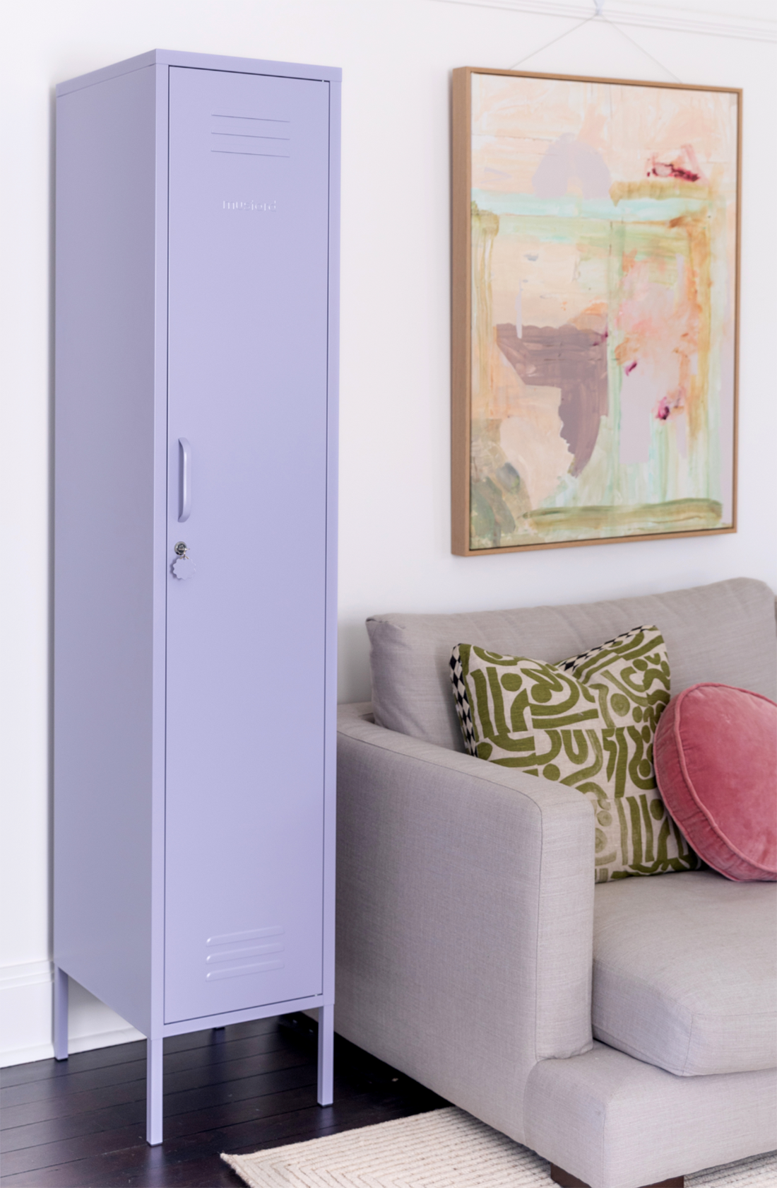 The skinny locker in lilac next to a couch.