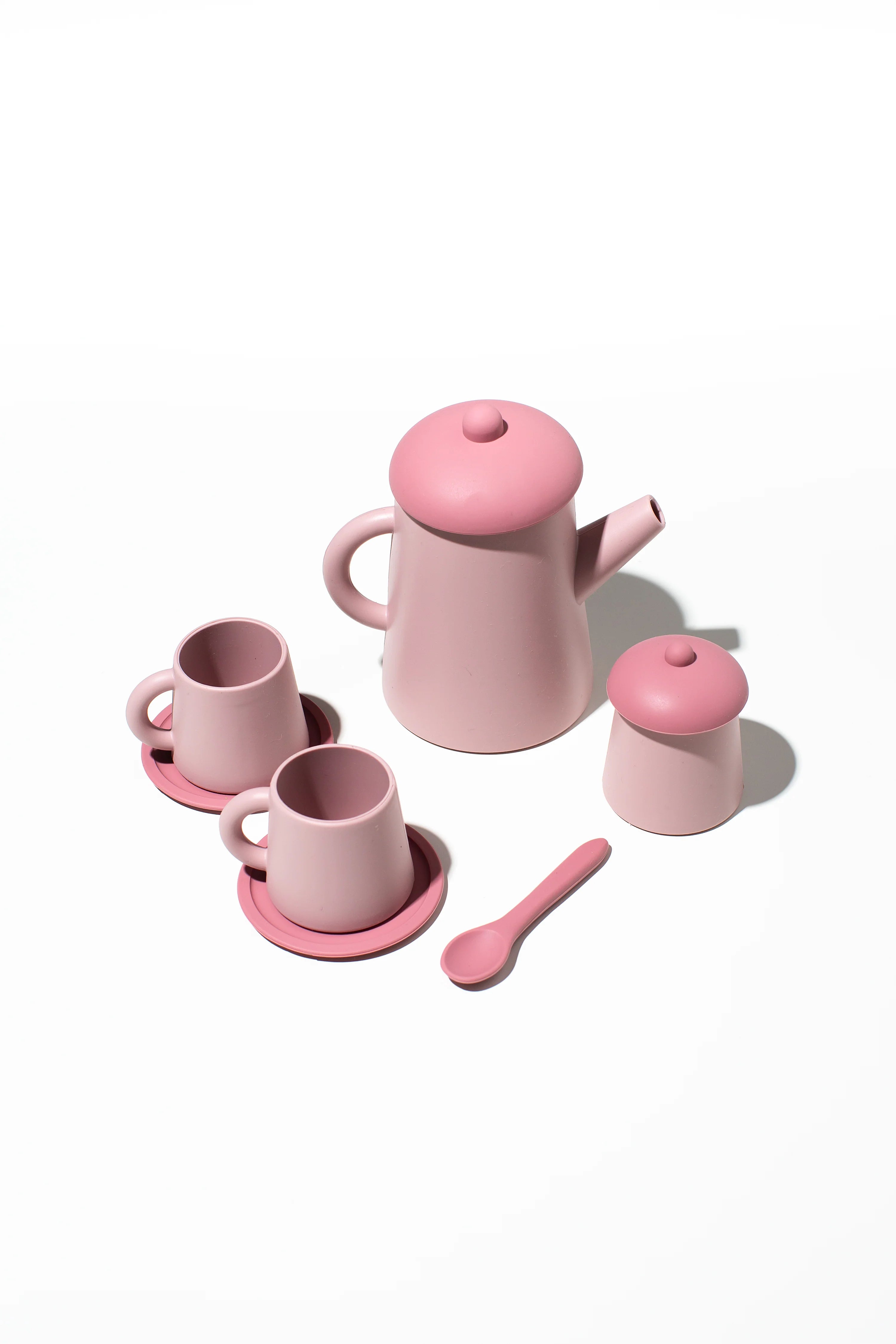 A pink, BPA-free Tea Time Set Pink by LITTLE DROP, including a teapot with a lid, two teacups on saucers, a sugar bowl with a lid, and a spoon, all neatly arranged on a white background. Perfect for little ones' sustainable tea time sets.