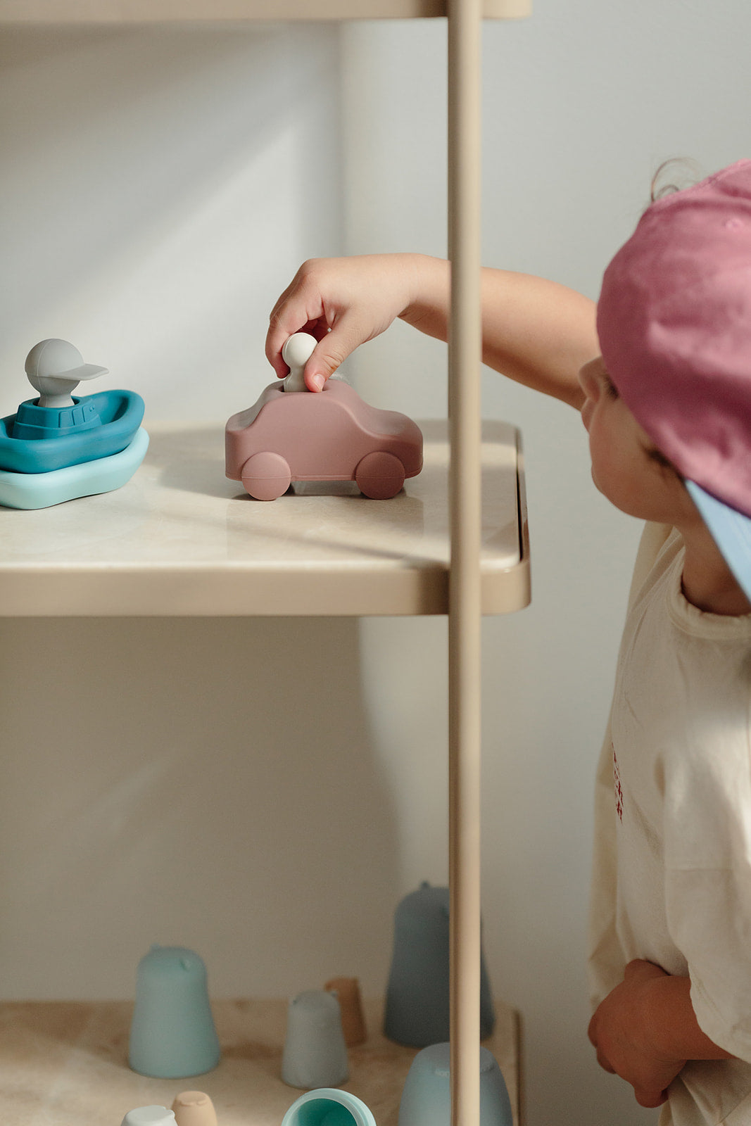 Boy playing with car toy on shelves