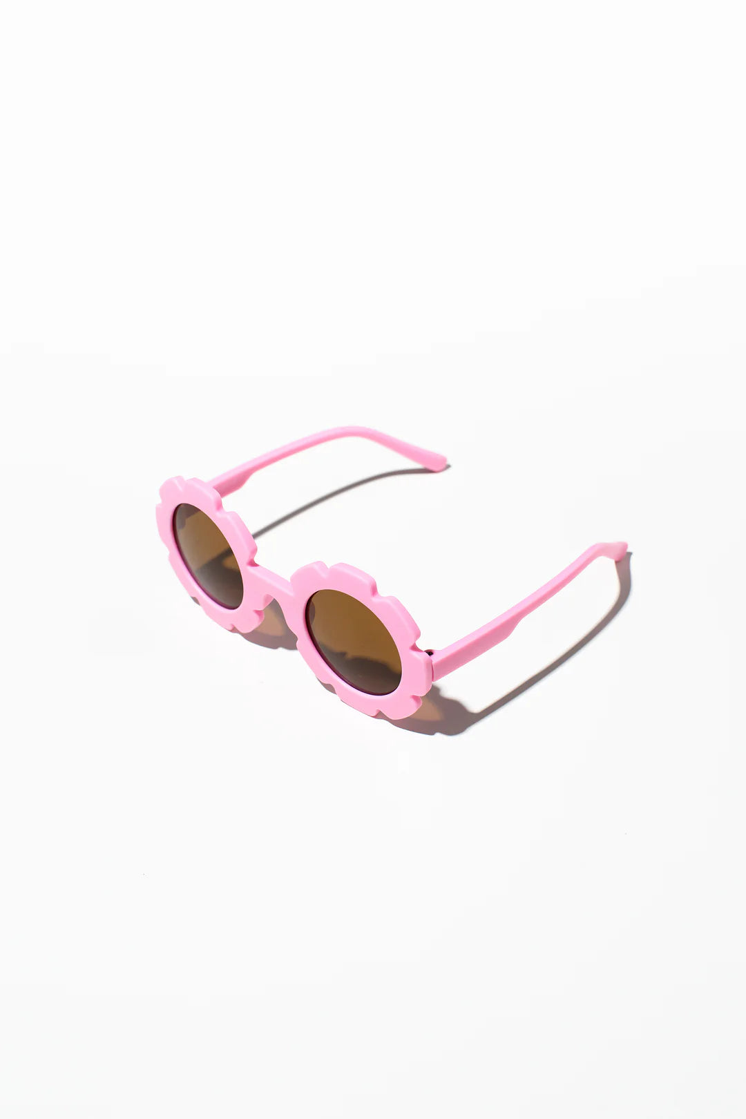 The Daisy Shades Berry Pink by LITTLE DROP, featuring pink, flower-shaped frames and dark lenses, are set against a clean, white background. The playful design is complemented by UV400 protection, making these kids' sunglasses a fashionable accessory.