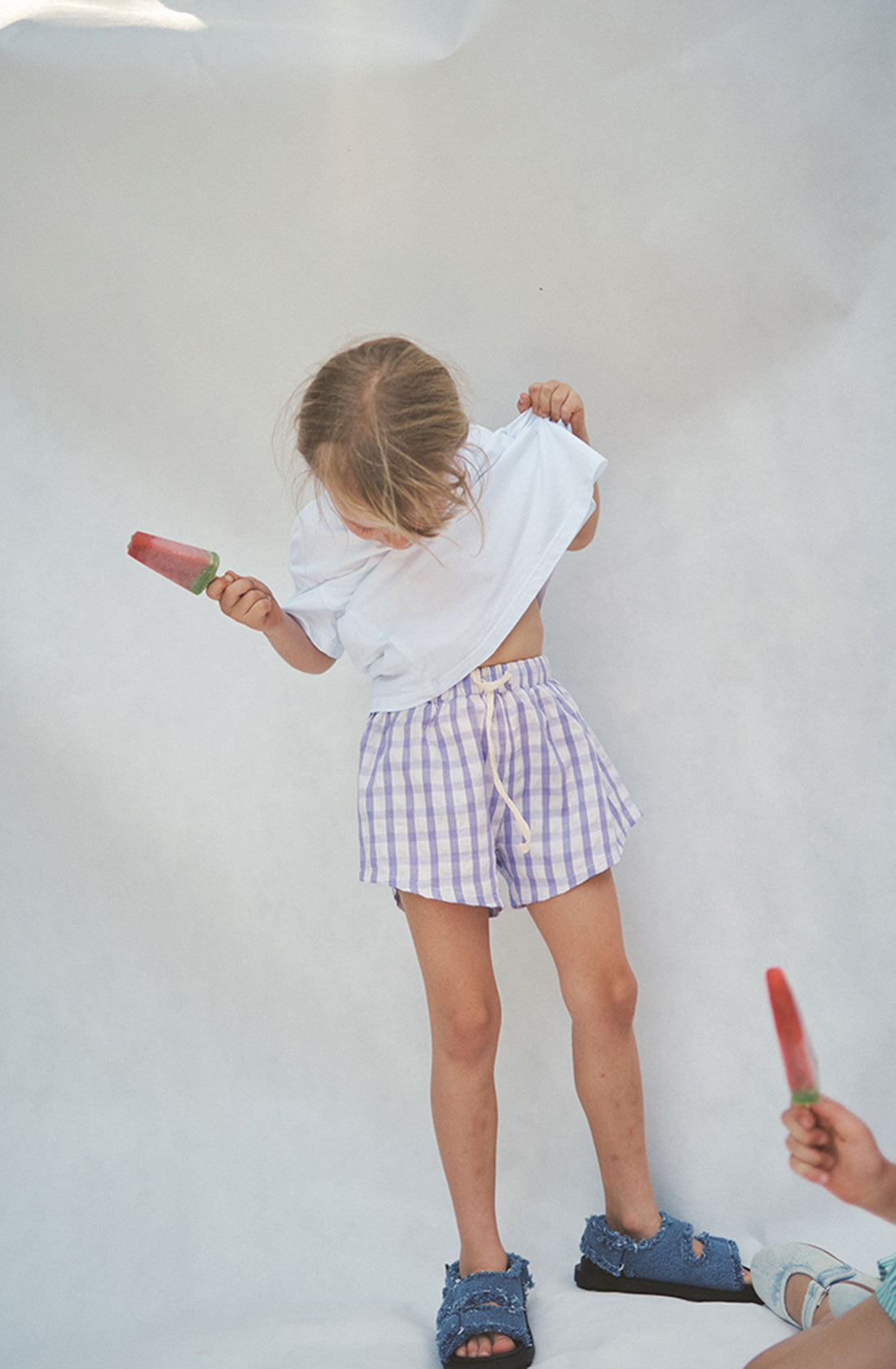 Girl holding icy pole and pulling up her t-shirt to show the Cami shorts